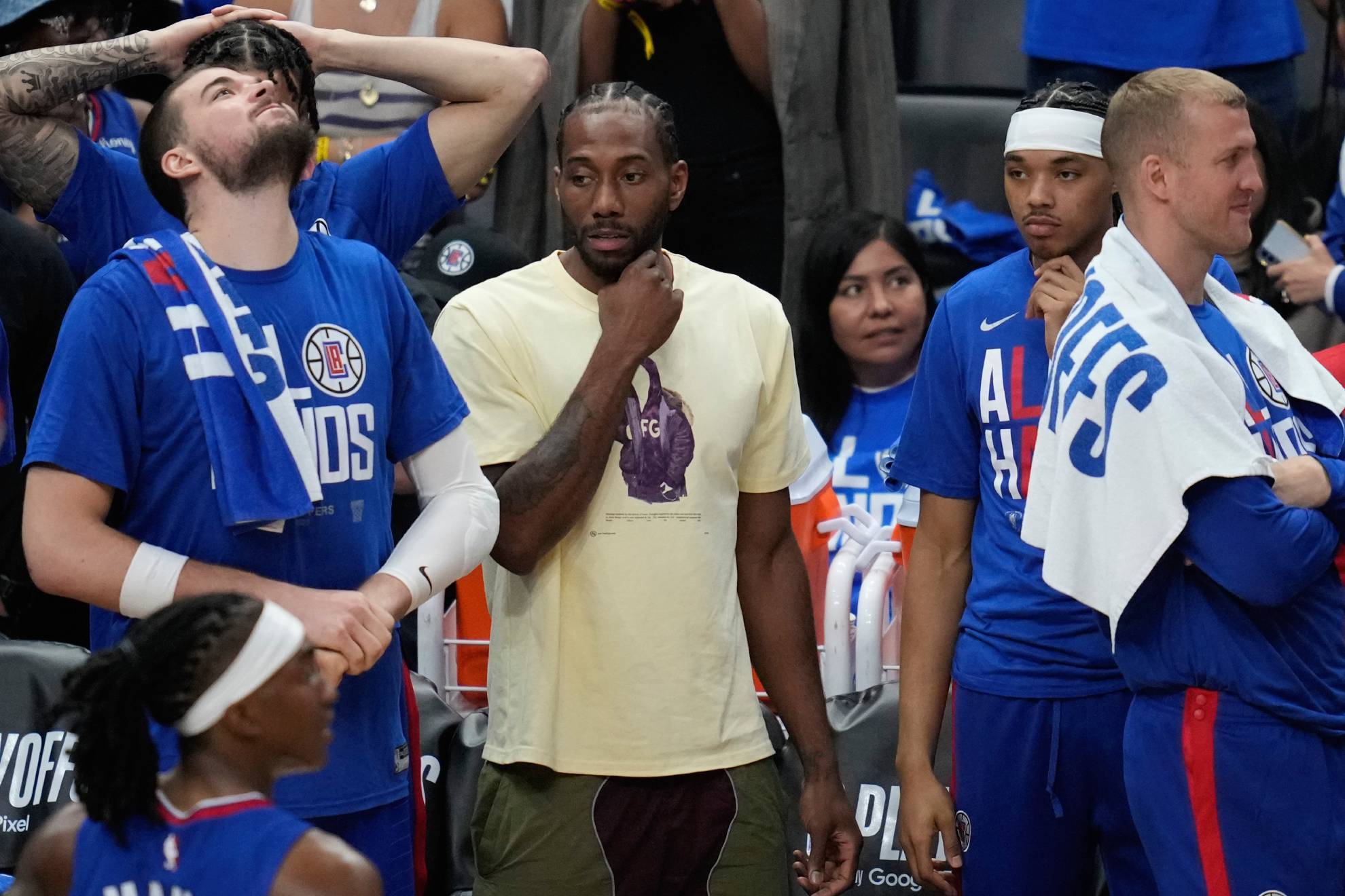 Kawhi Leonard, en el centro con ropa de calle, durante un partido de los Clippers.
