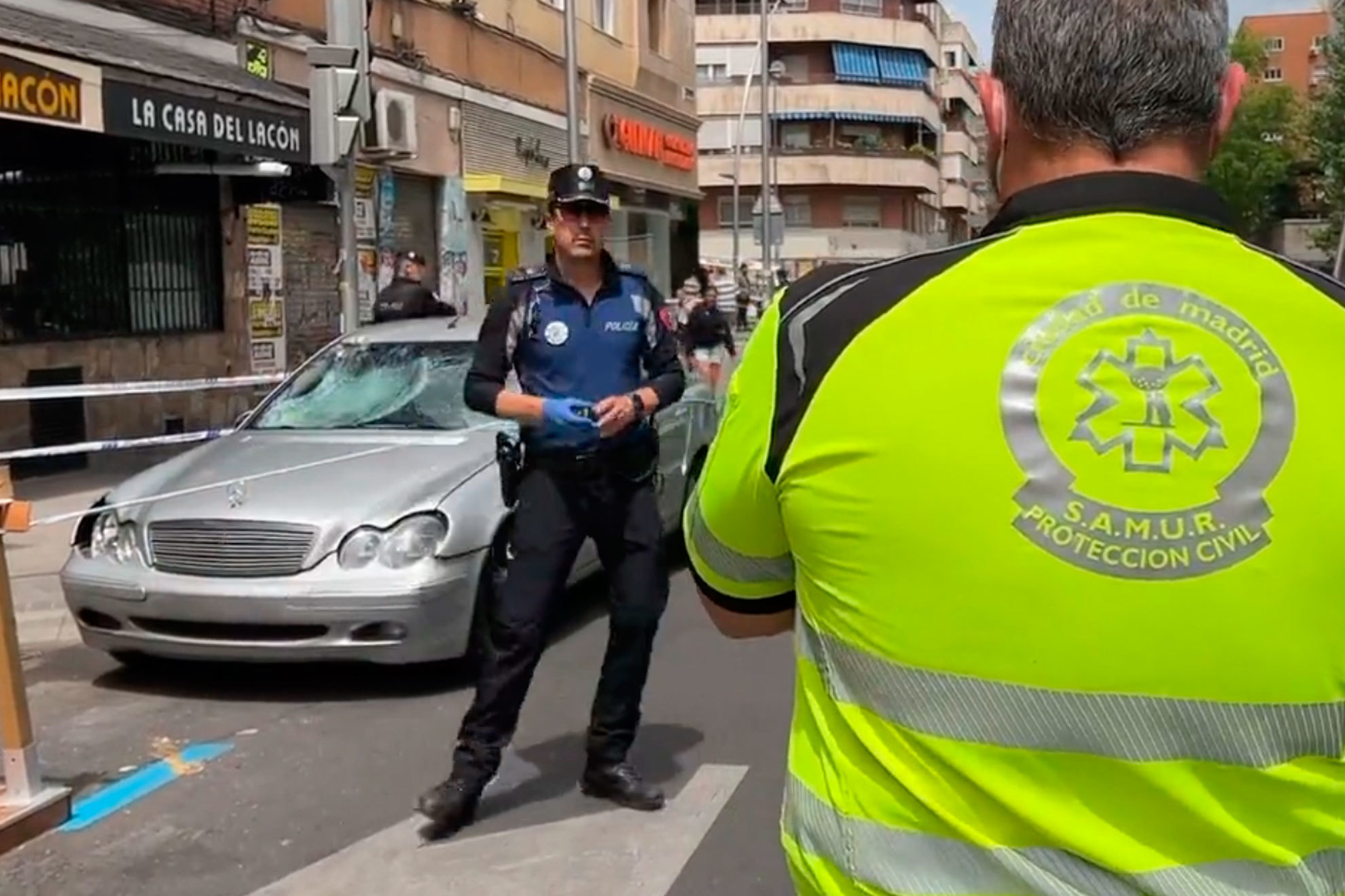 Un agente de la Polica Municipal de Madrid y un miembro de Emergencias Madrid, junto al coche en el que se produjeron los atropellos.