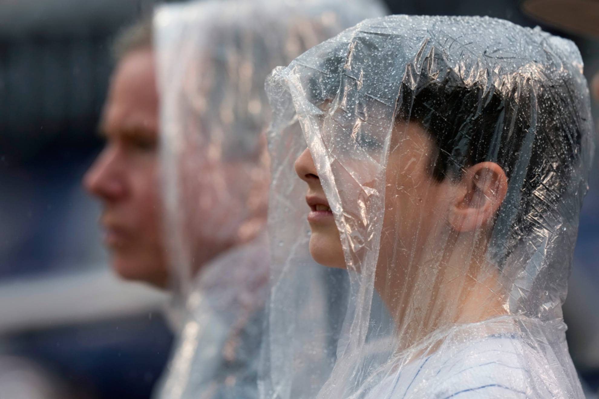 Fans wear rain ponchos during the first inning of a baseball game between the Washington Nationals and the New York Mets