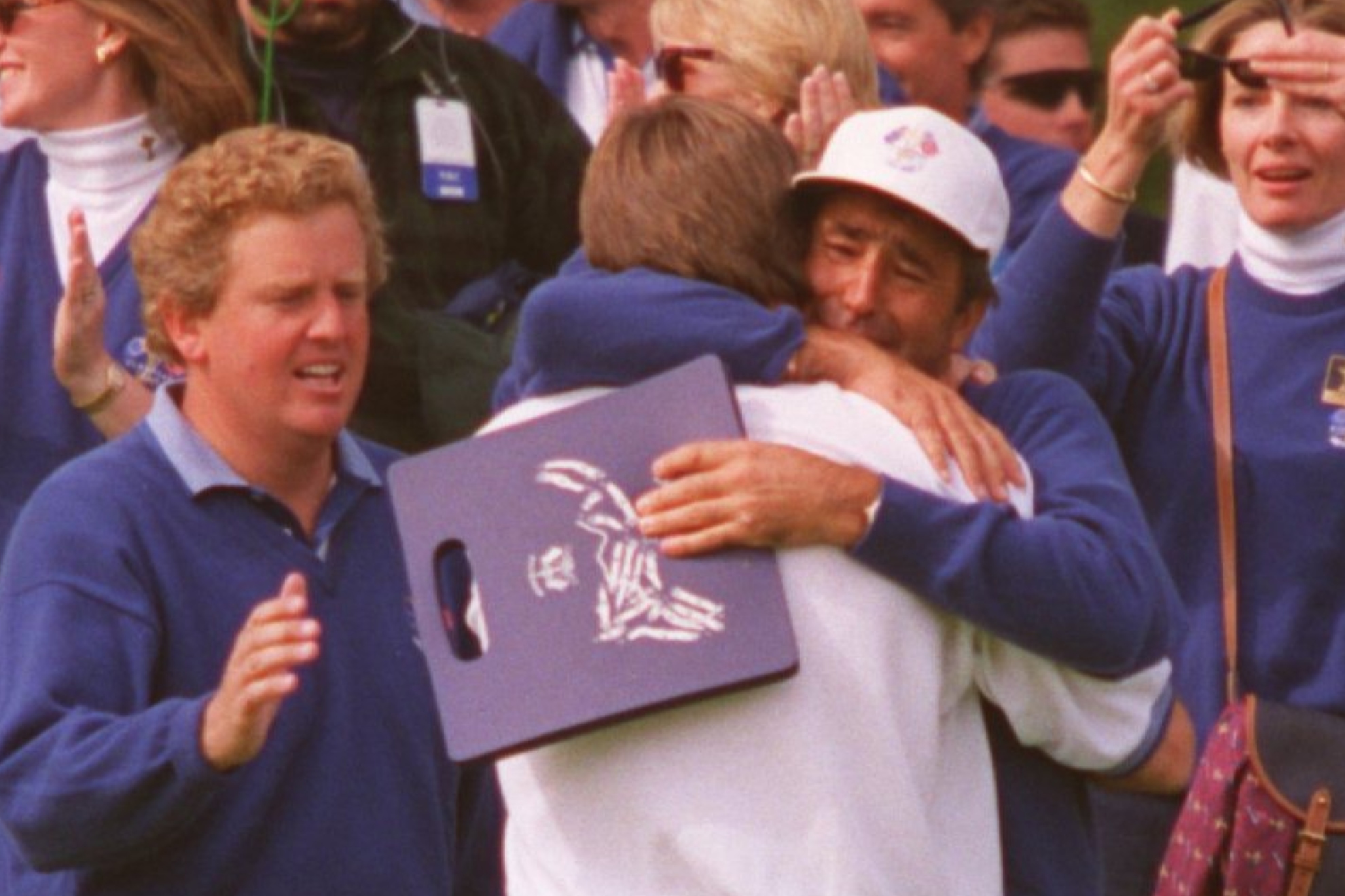 Severiano Ballesteros abraza a Nick Faldo después de que este metiera el putt con el que ganó a Curtis Strange en la Ryder Cup de 1995. A la izquierda de la imagen, Montgomerie se acerca a ellos.