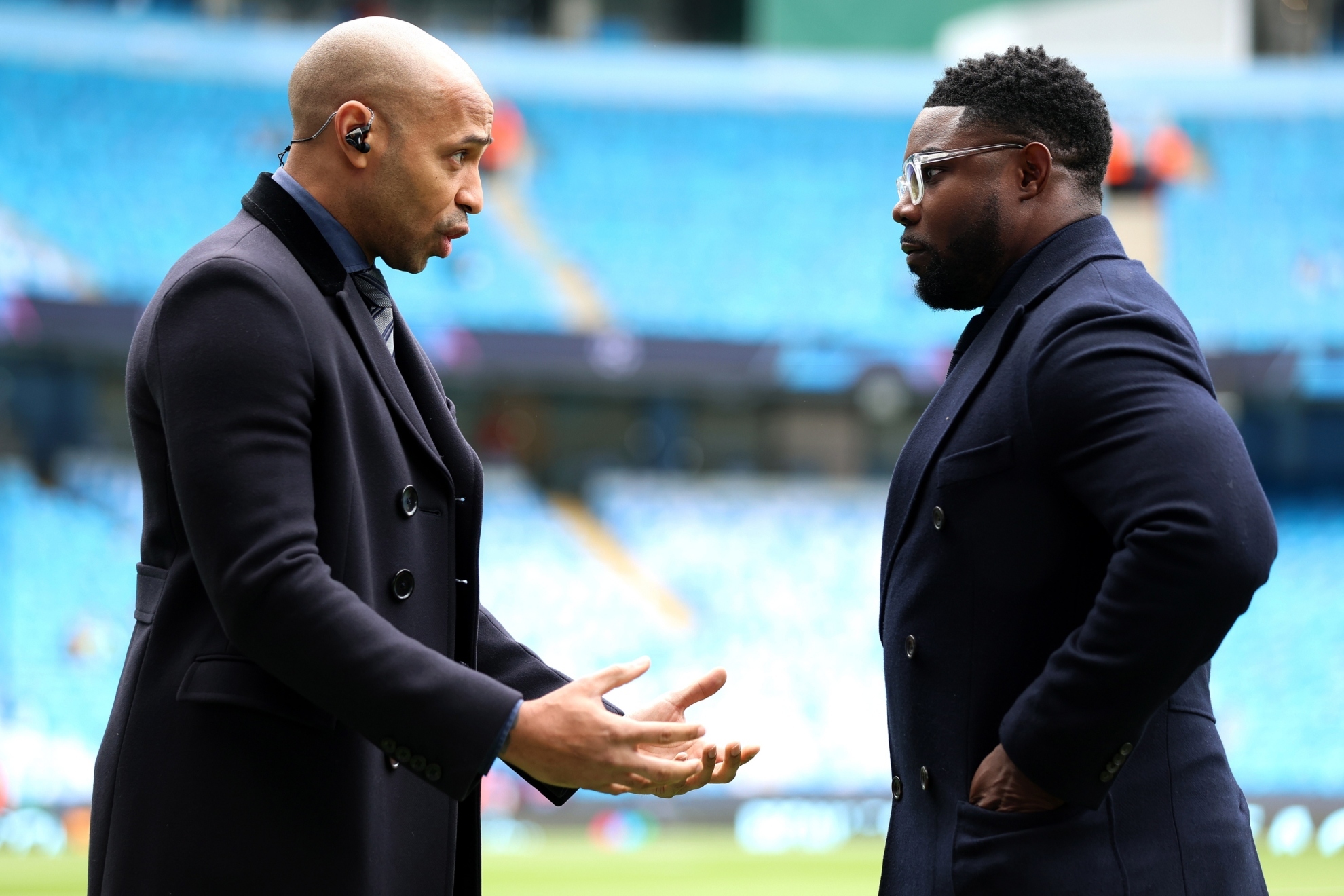 Micah Richards dialoga con Thierry Henry en la previa de un partido del City.