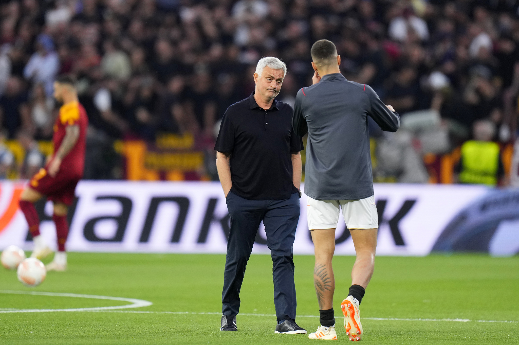 Roma head coach Jose Mourinho walks towards Sevilla's Erik Lamela, right, during warmup before the Europa League final 