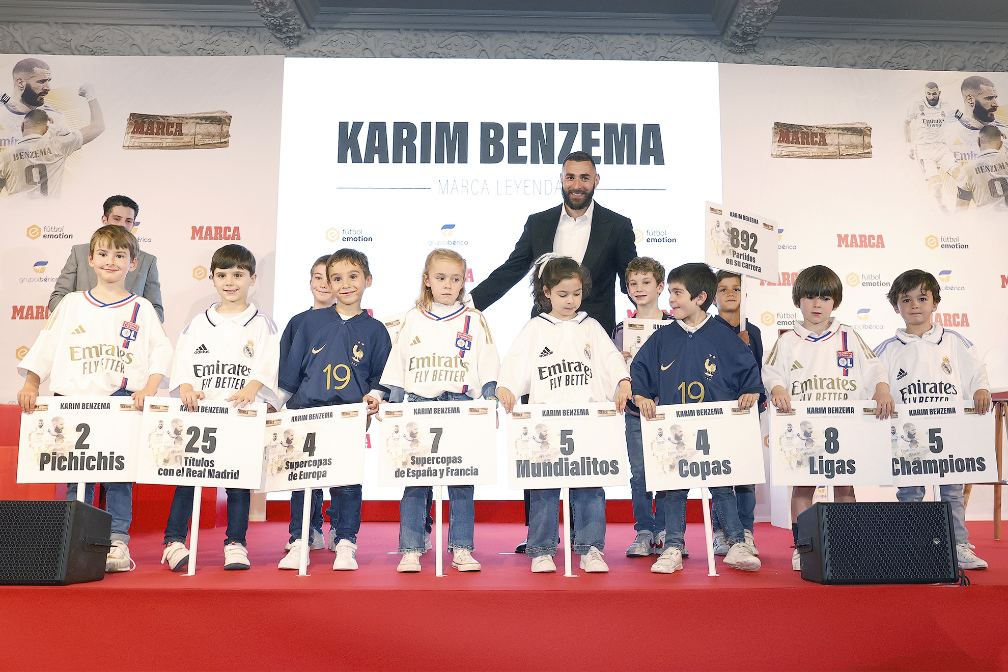 Karim Benzema posa junto a 10 niños durante la entrega del MARCA Leyenda ayer en Madrid.