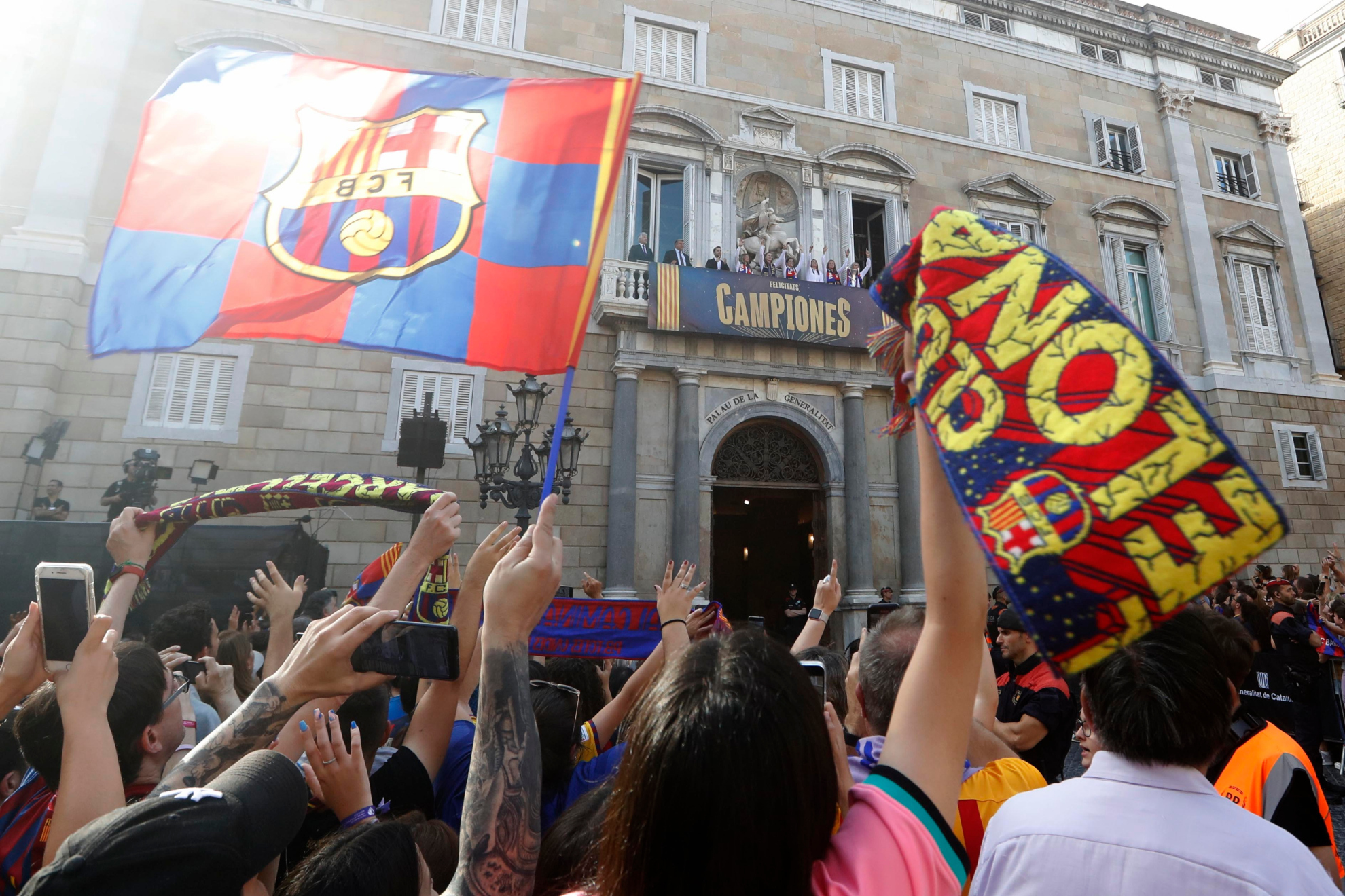 Las jugadoras del Barça saludan desde el balcón del palacio de la Generalitat a los aficionados.