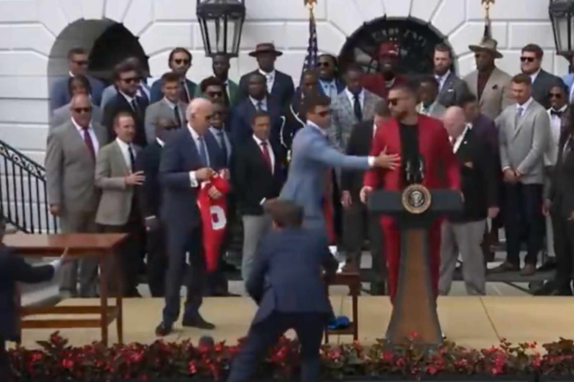 Mahomes ushers Kelce off White House lawn mic, as President Joe Biden watches.
