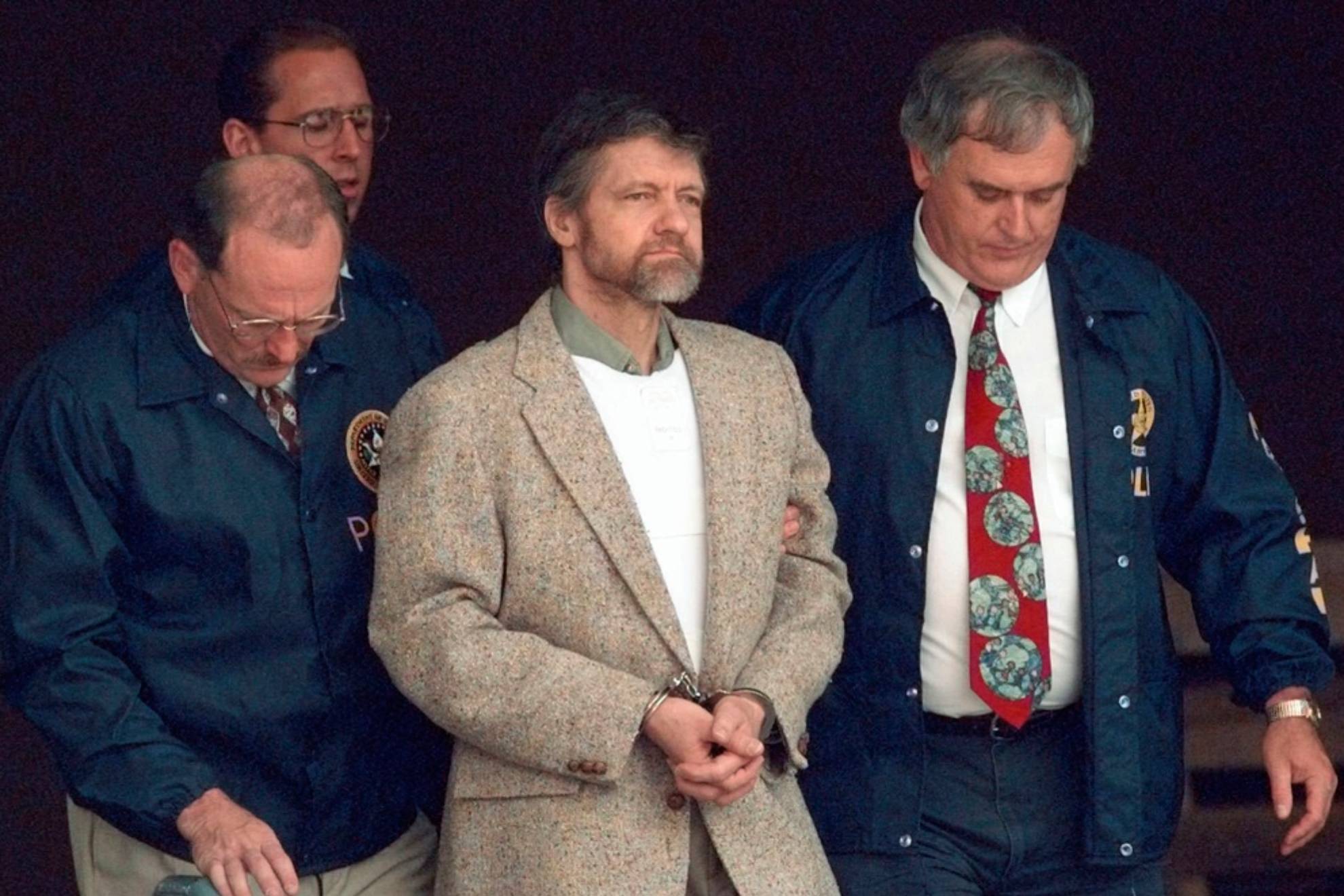 Theodore Kaczynski looks around as U.S. Marshals prepare to take him down
