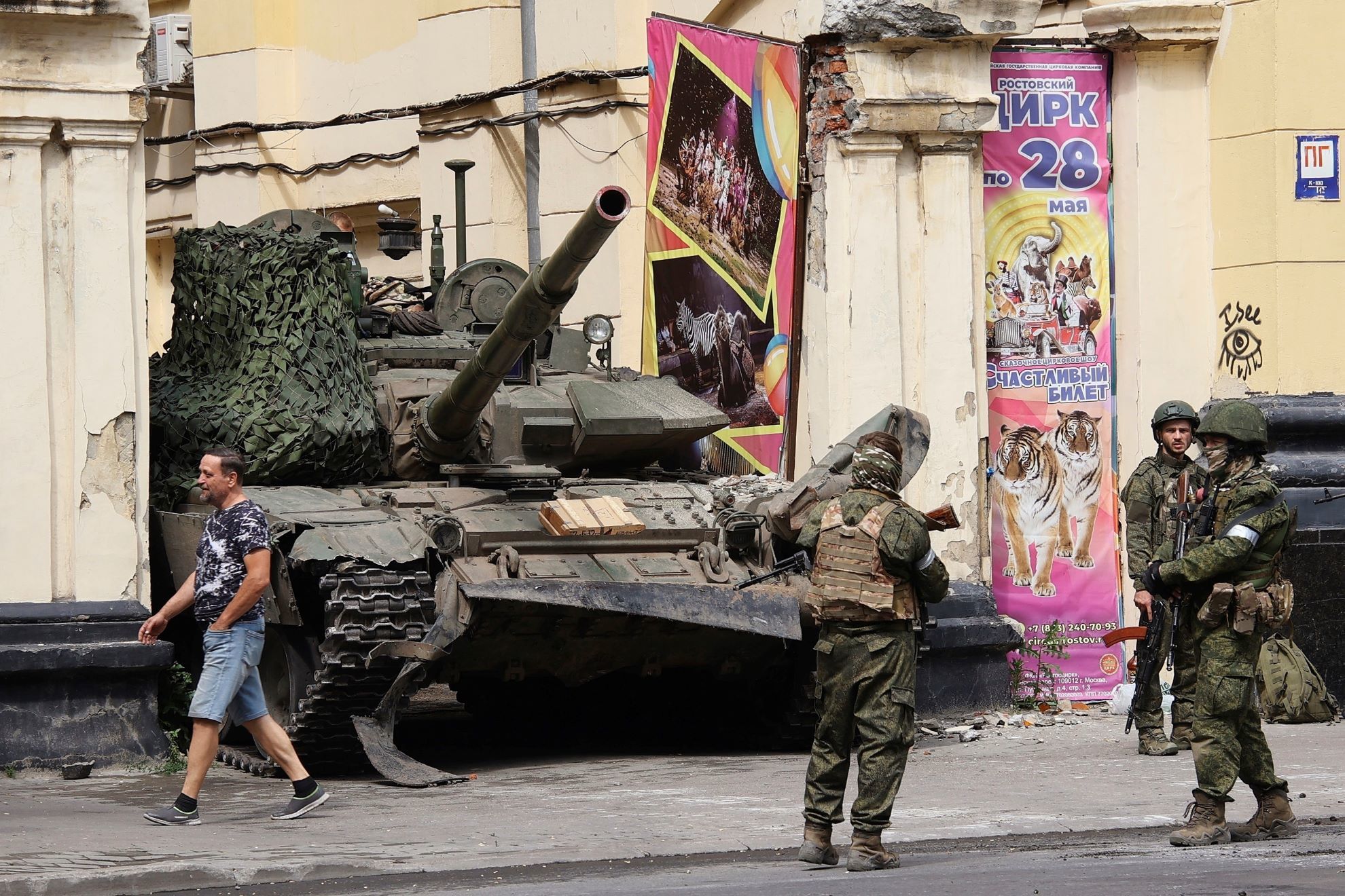Russian servicemen guard an area standing in front of a tank in a street in Rostov-on-Don.