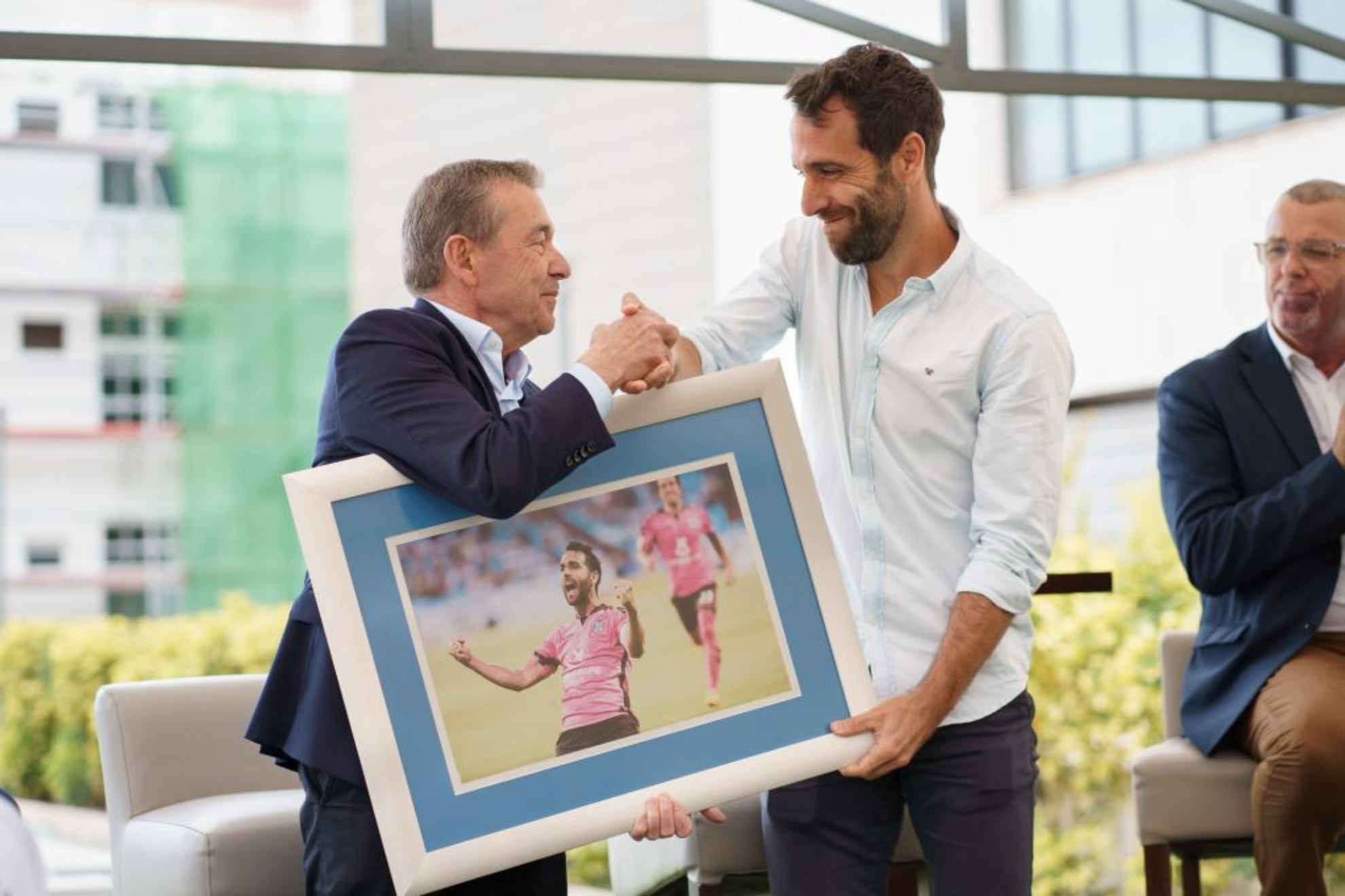 El presidente del CD Tenerife, Paulino Rivero entrega una fotografía al jugador Carlos Ruiz.