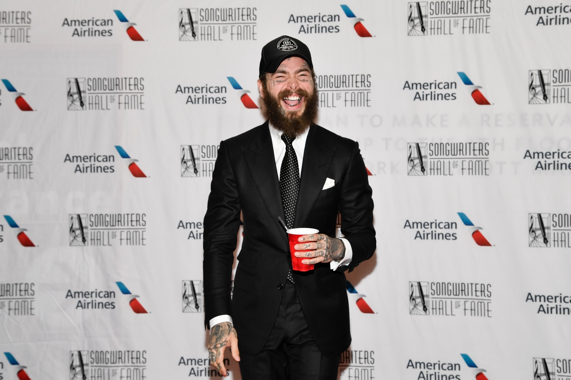 Post Malone at an award ceremonys red carpet.