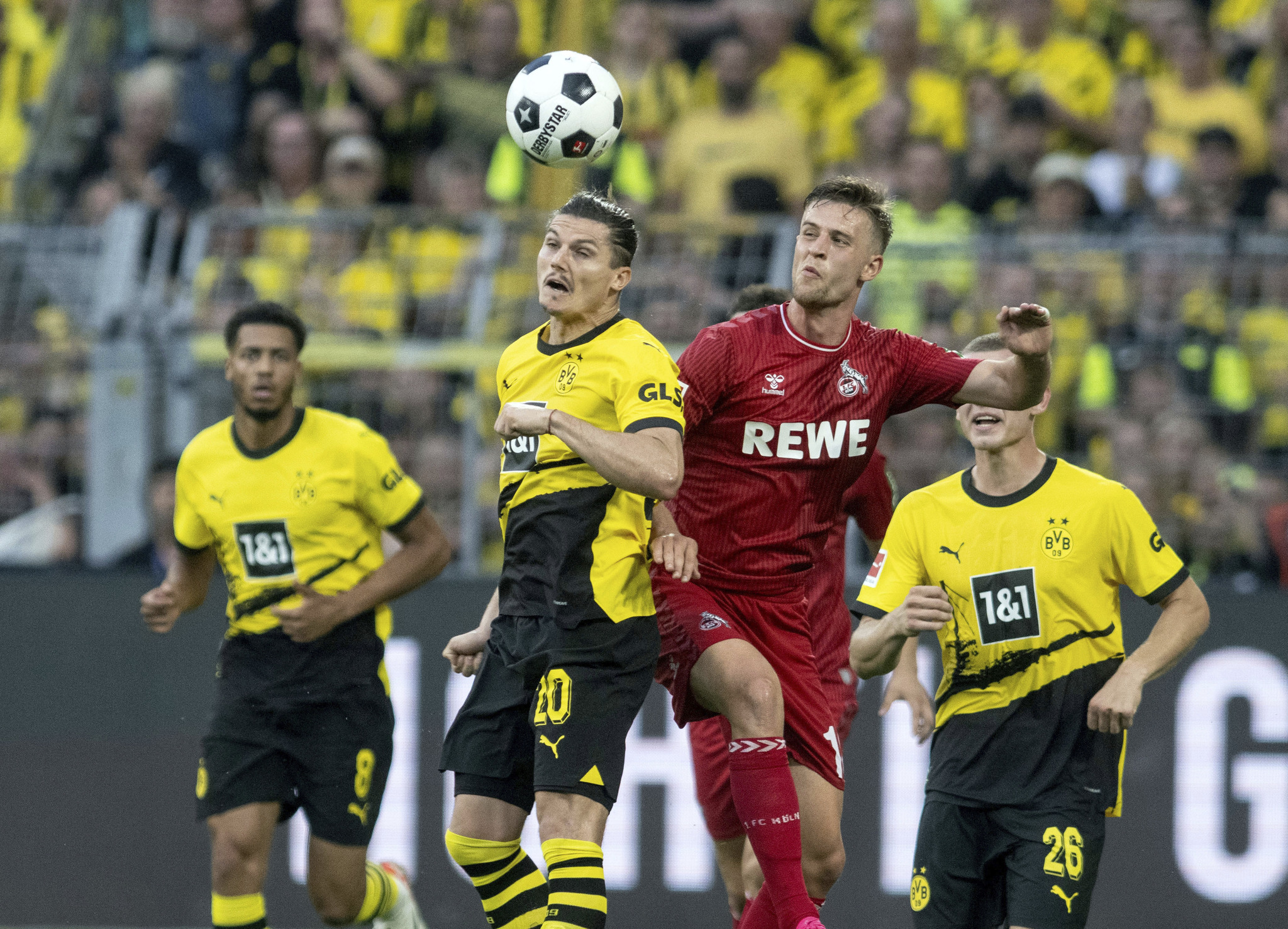 Un duelo entre jugadores del Dortmund y el Colonia.