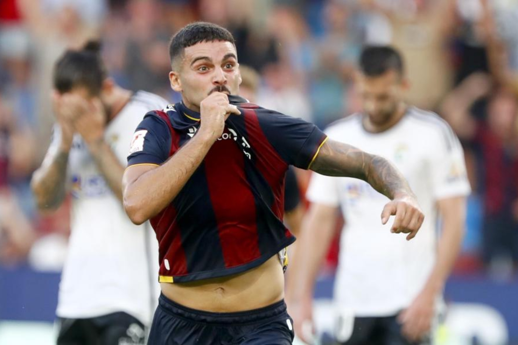Sergio Lozano celebra su gol con el Levante ante la desesperación de los jugadores del Burgos.