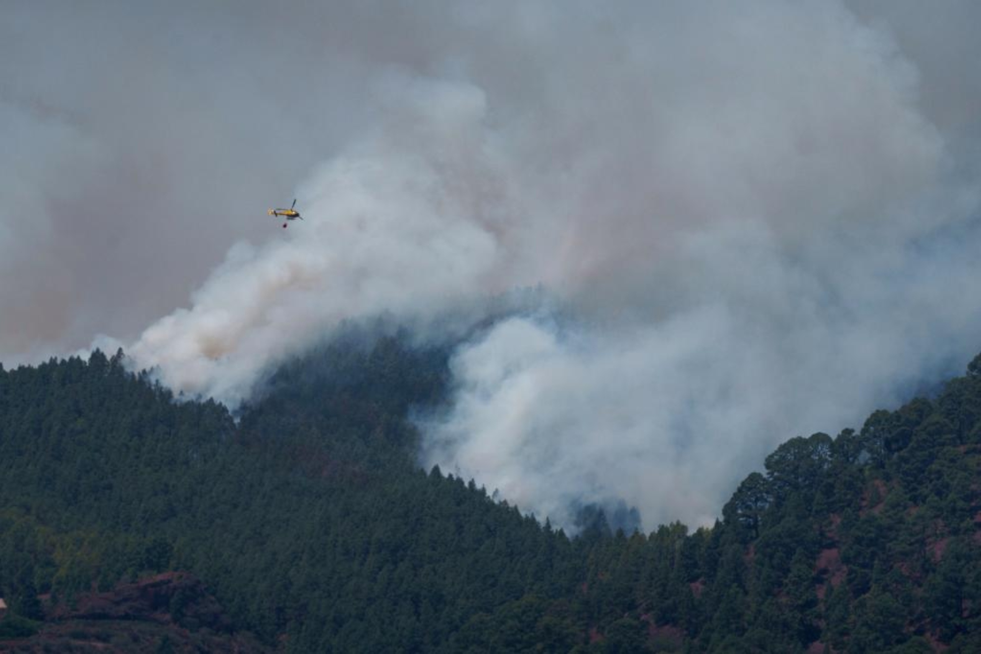 Un helicóptero trabaja en la extinción del incendio forestal en los altos de Güímar en Tenerife.