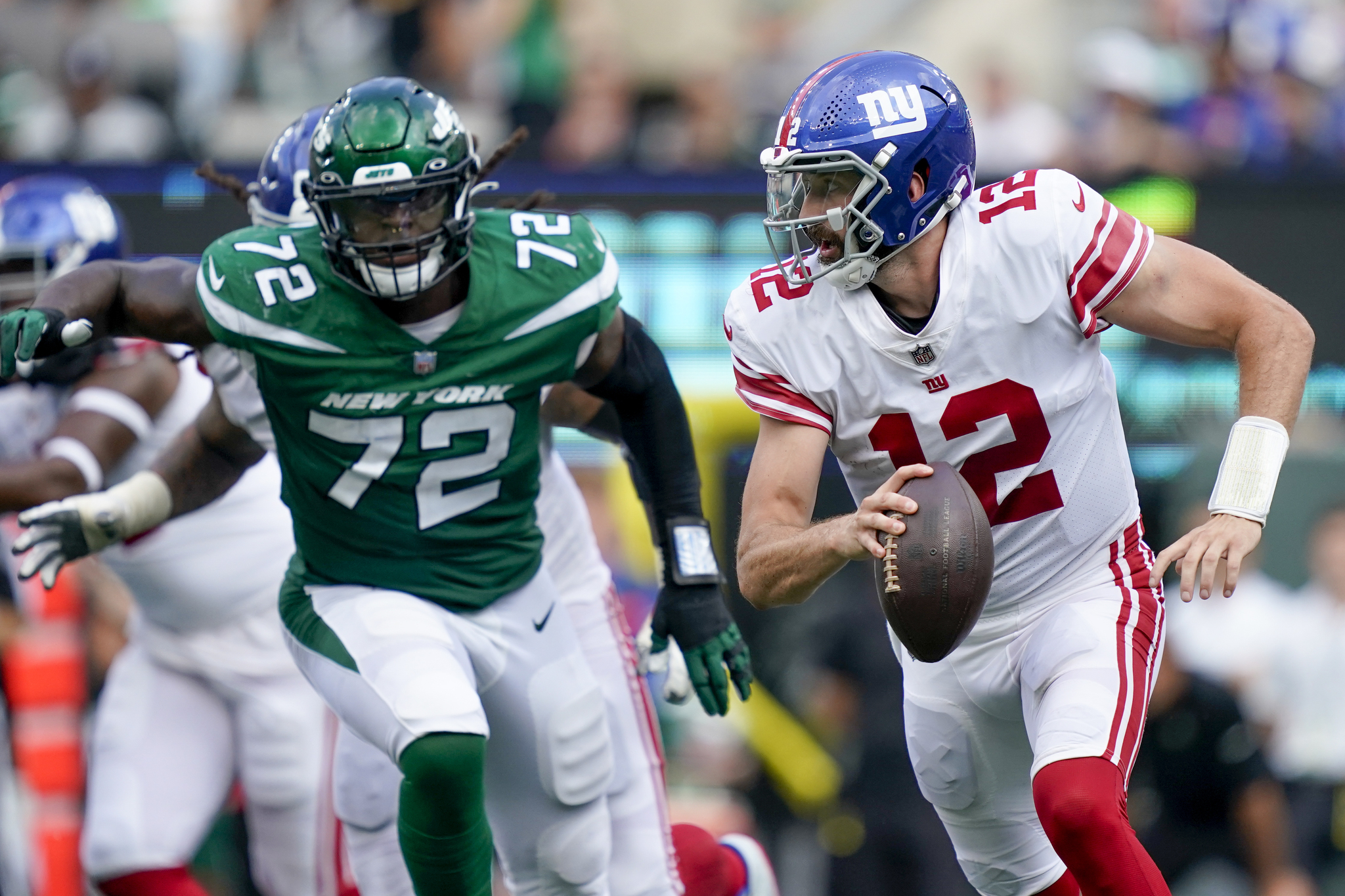 New York Giants quarterback looks to pass on the run in the second half of a preseason NFL football game against the Jets.