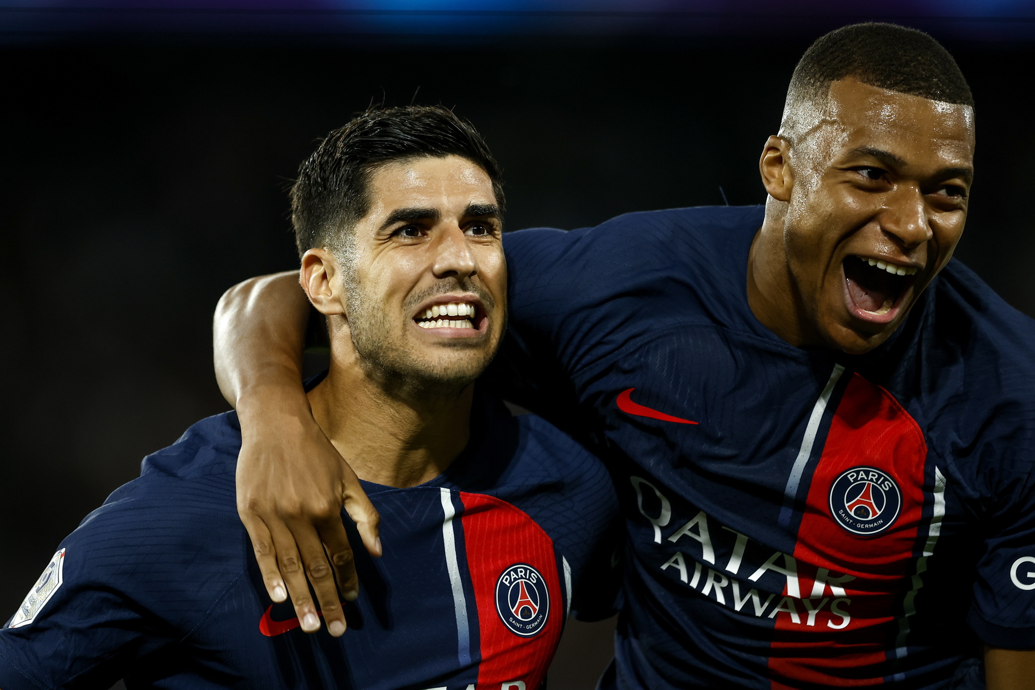 Marco Asensio celebrates with PSG teammate Kylian Mbappe (R) after scoring