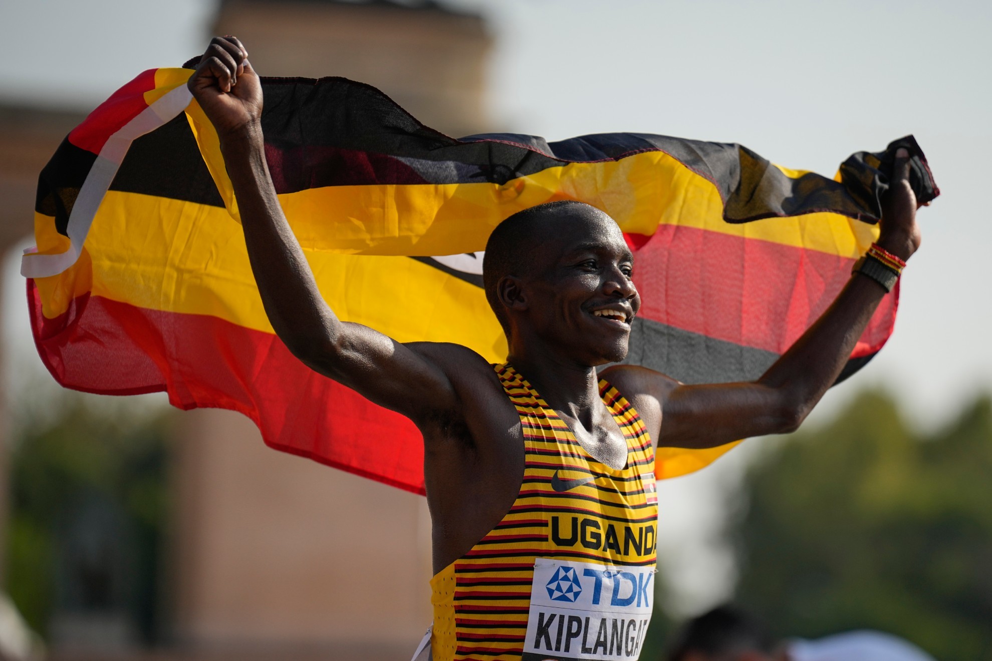 Victor Kiplangat enarbola la bandera de Uganda tras ganar el maratón de los mundiales de Budapest.