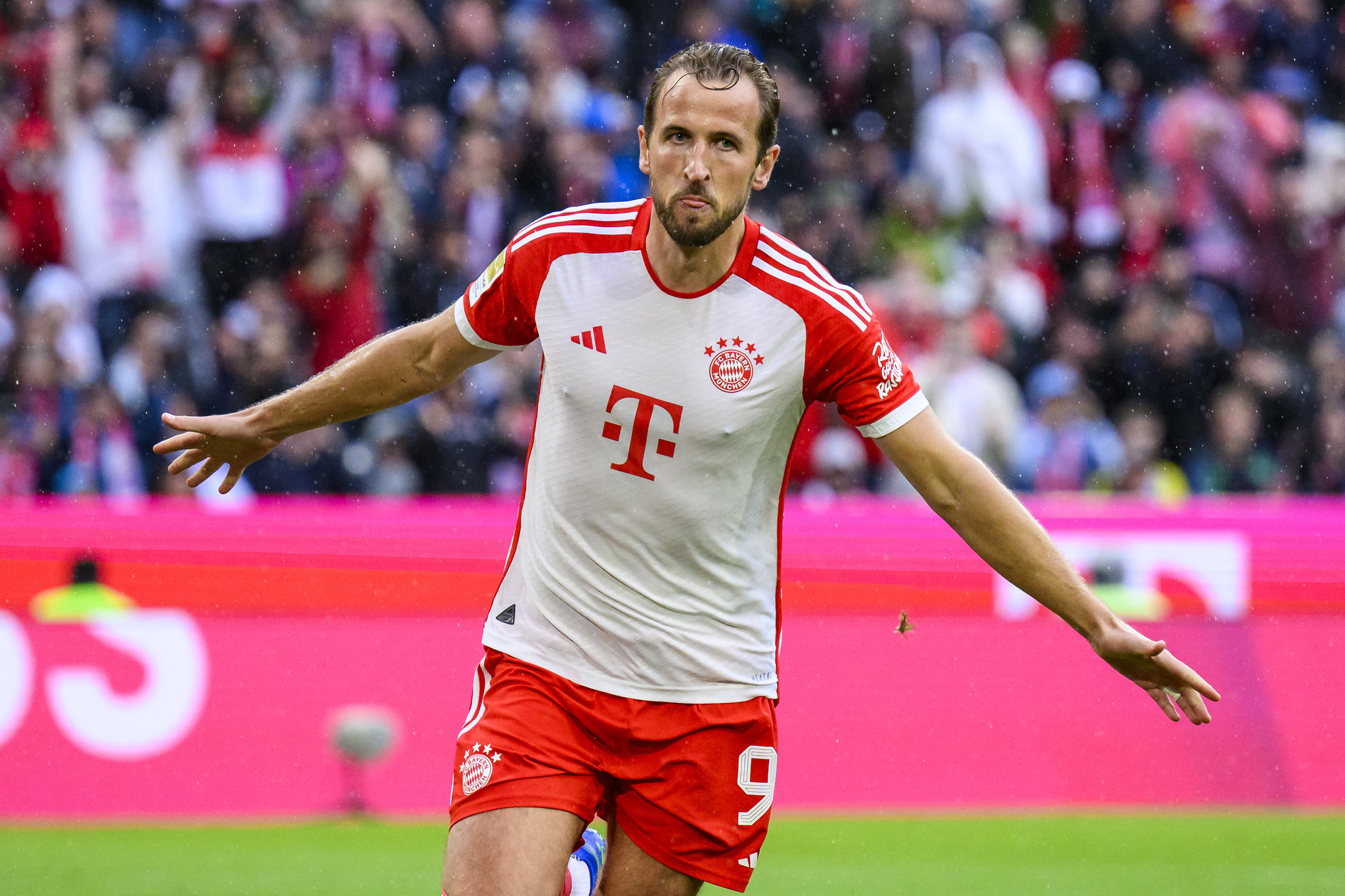  Harry Kane celebrates by spreading his arms wide after scoring a goal for Bayern Munich.