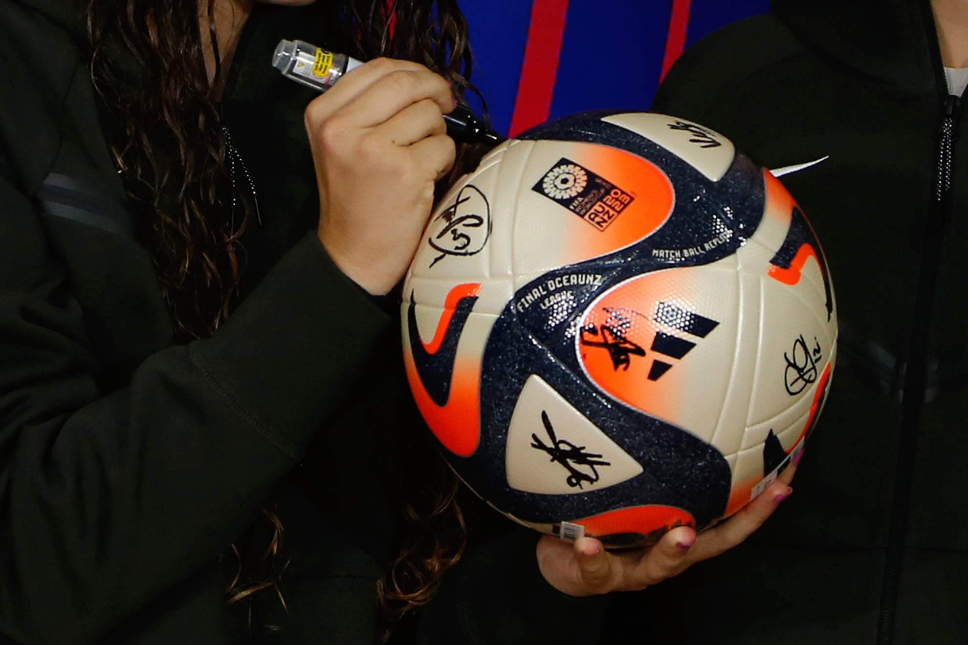 Futbolista firmando un balón / EFE