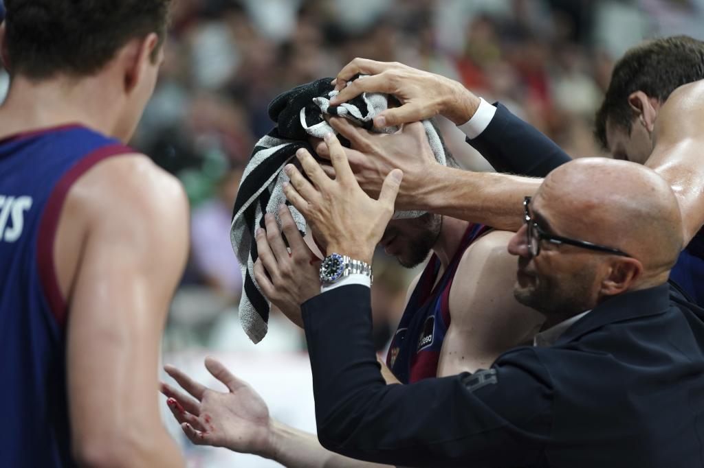 Darío Brizuela se marcha al vestuario con la cabeza cubierta por una toalla y con ayuda de los médicos del Barça.