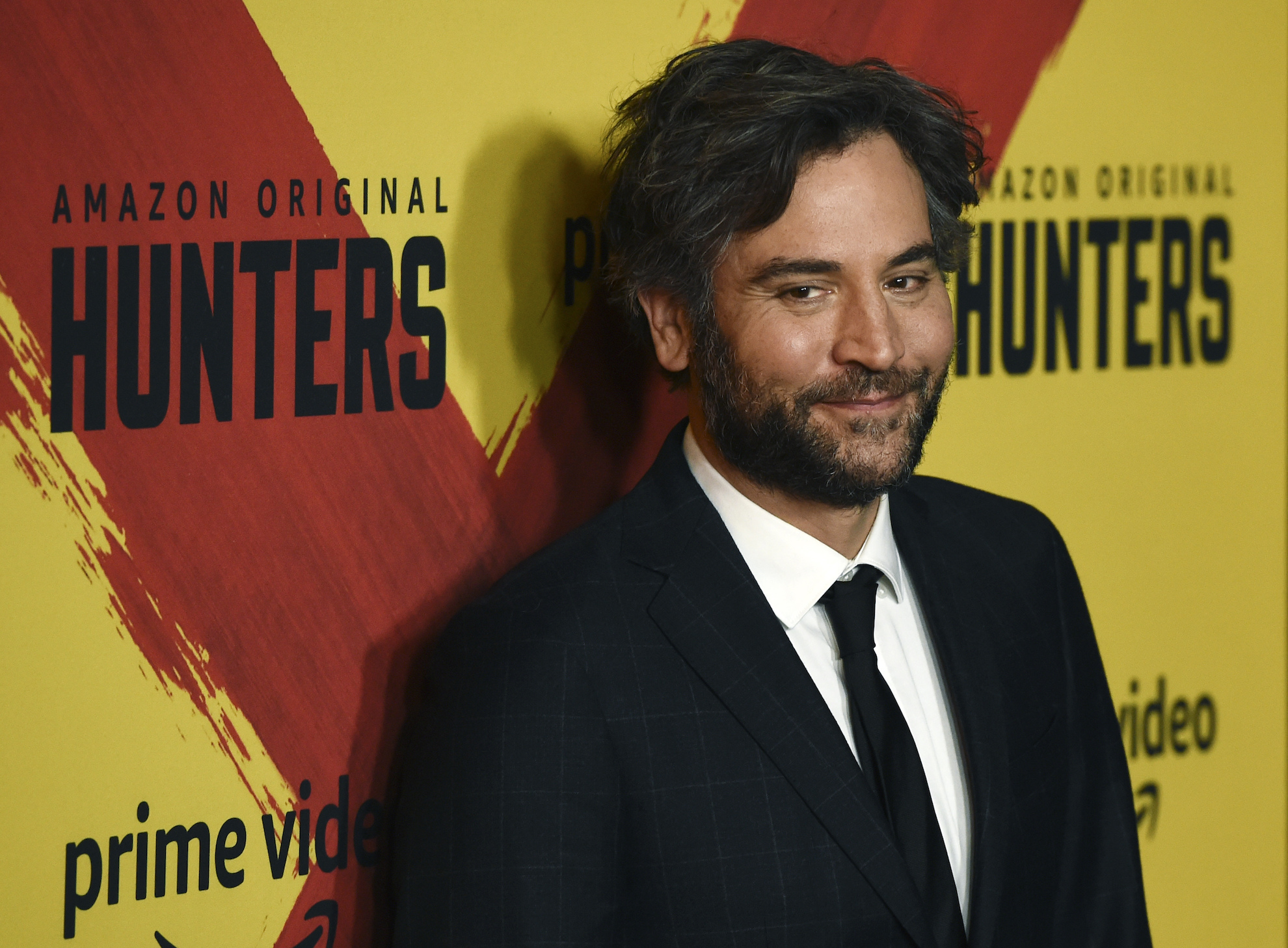 Josh Radnor, a cast member in the Amazon Prime Video series "Hunters," poses at the premiere of the show at the Directors Guild of America, Wednesday, Feb. 19, 2020, in Los Angeles. (AP Photo/Chris Pizzello)