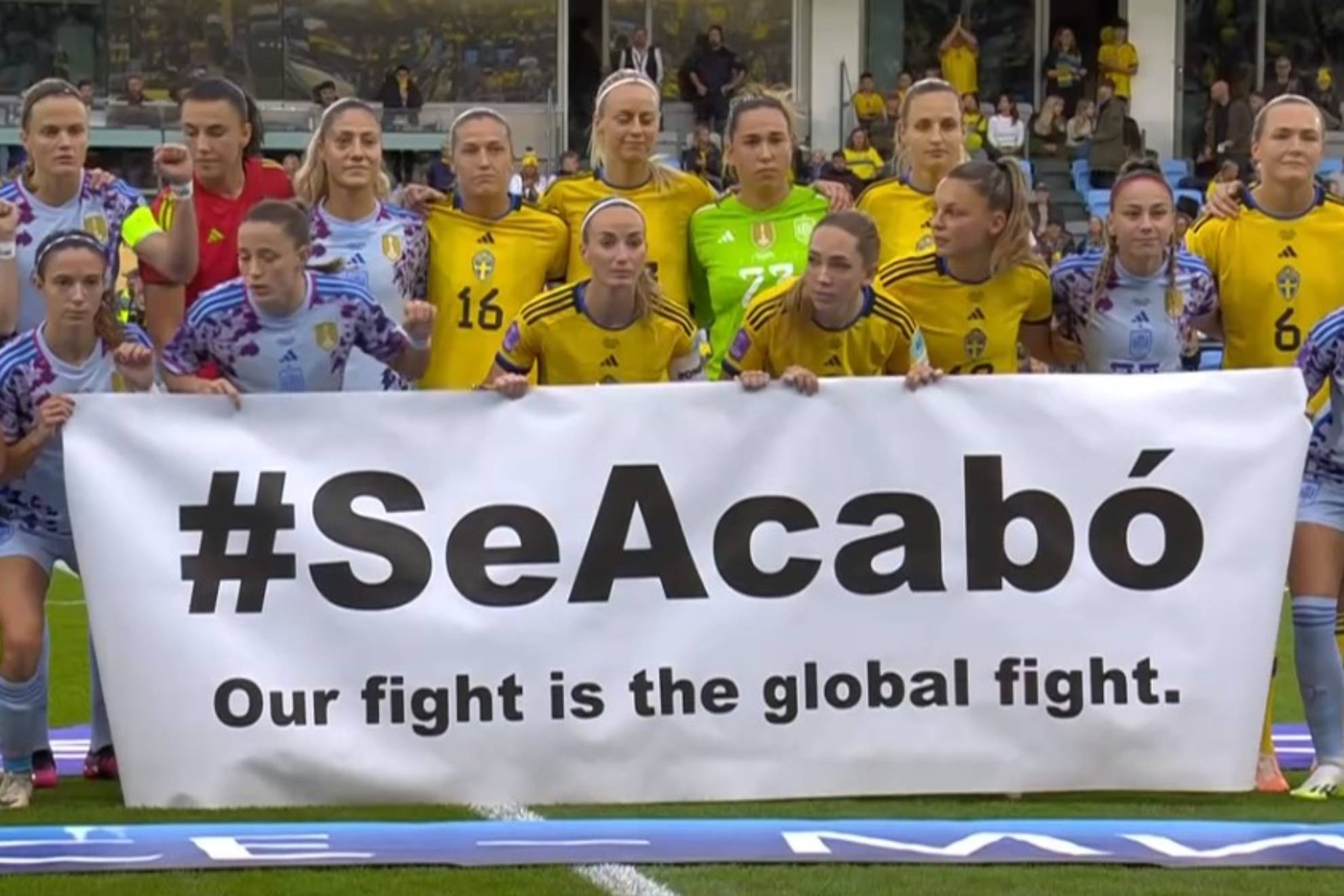 Las jugadoras de Suecia y España posan con la pancarta