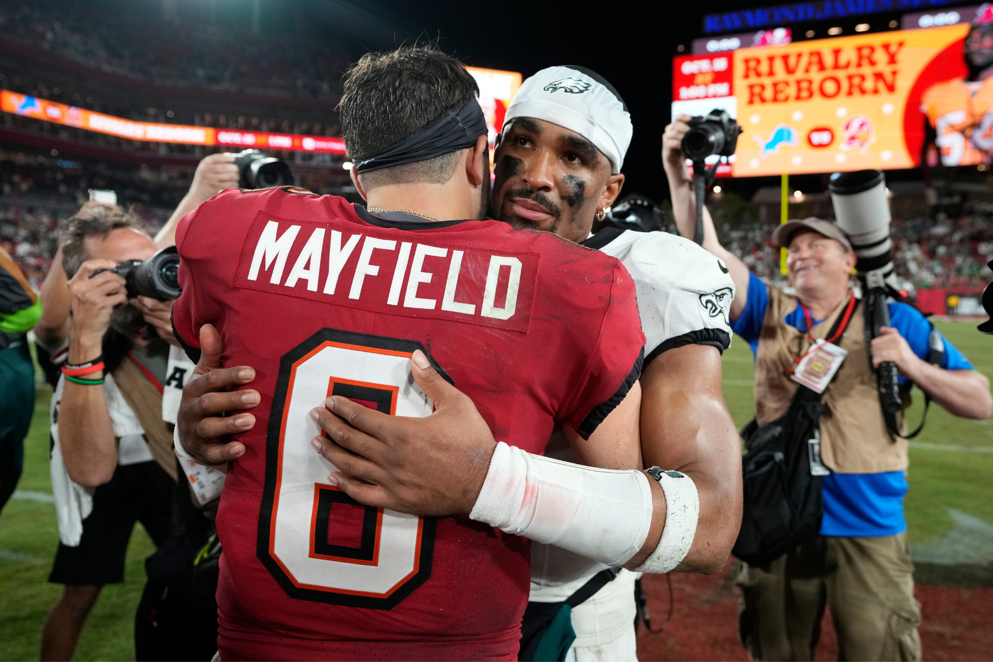 Jalen Hurts embraces Baker Mayfield following the Eagles' victory.