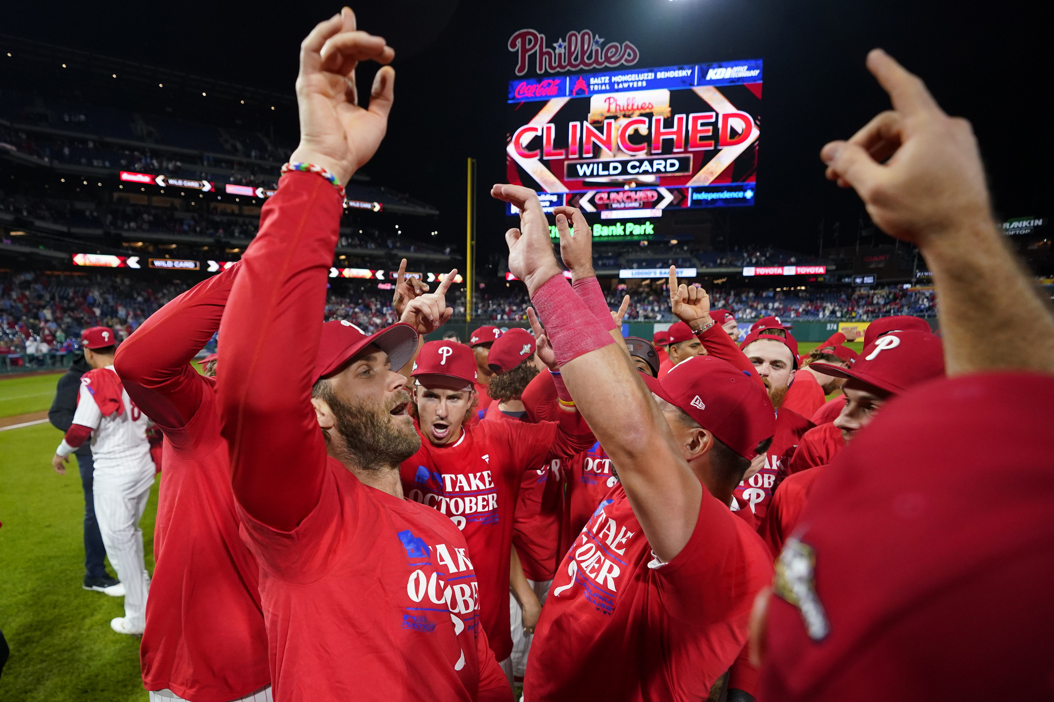 Philadelphia Phillies' Bryce Harper celebrates with teammates after their win in a baseball game against the Pittsburgh Pirates to clinch a wild-card playoff spot.
