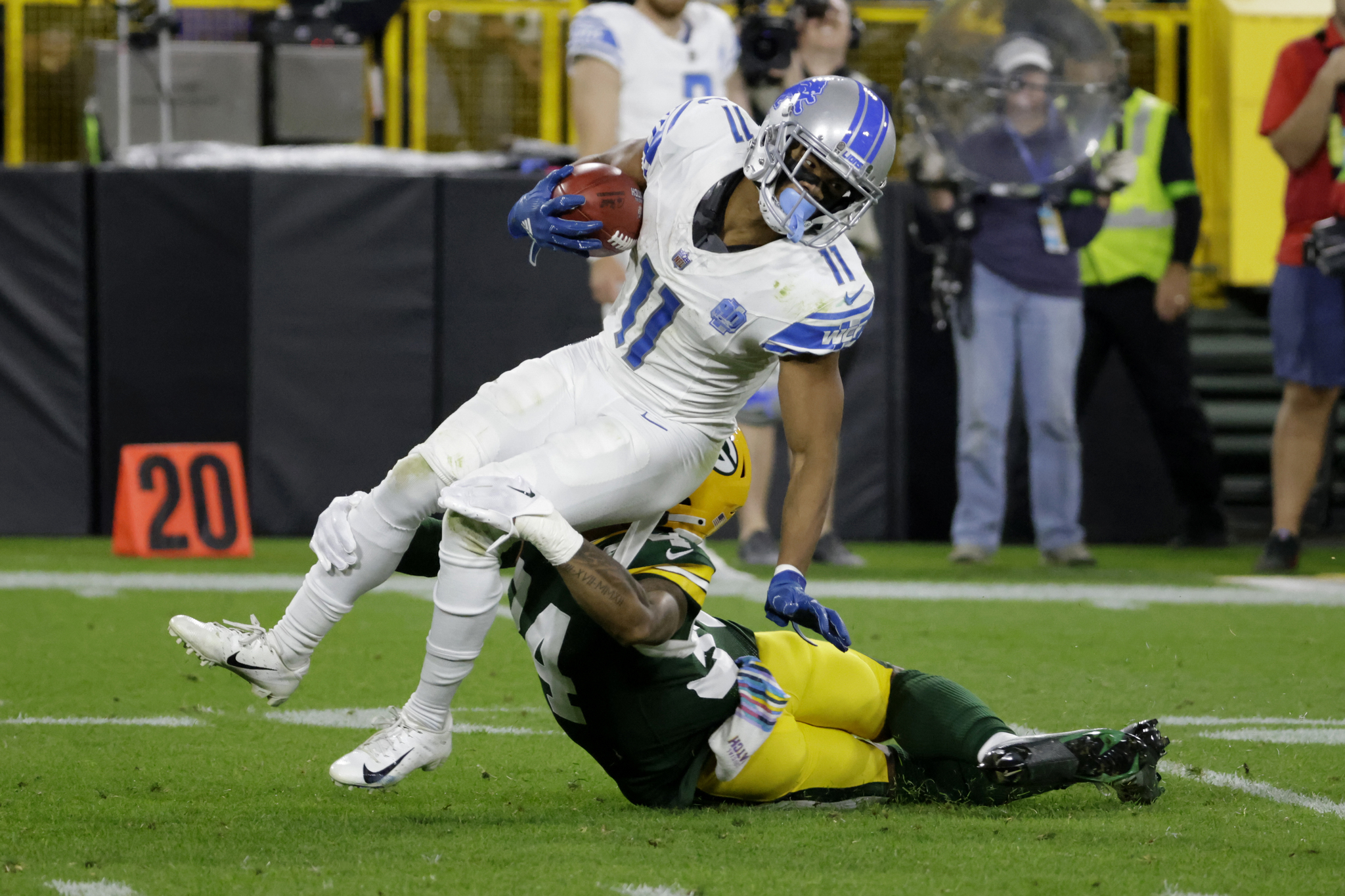 Detroit Lions wide receiver Kalif Raymond (11) is tackled by Green Bay Packers safety Jonathan Owens (34) after catching a pass during the first half of an NFL football game, Thursday, Sept. 28, 2023, in Green Bay, Wis. (AP Photo/Mike Roemer)