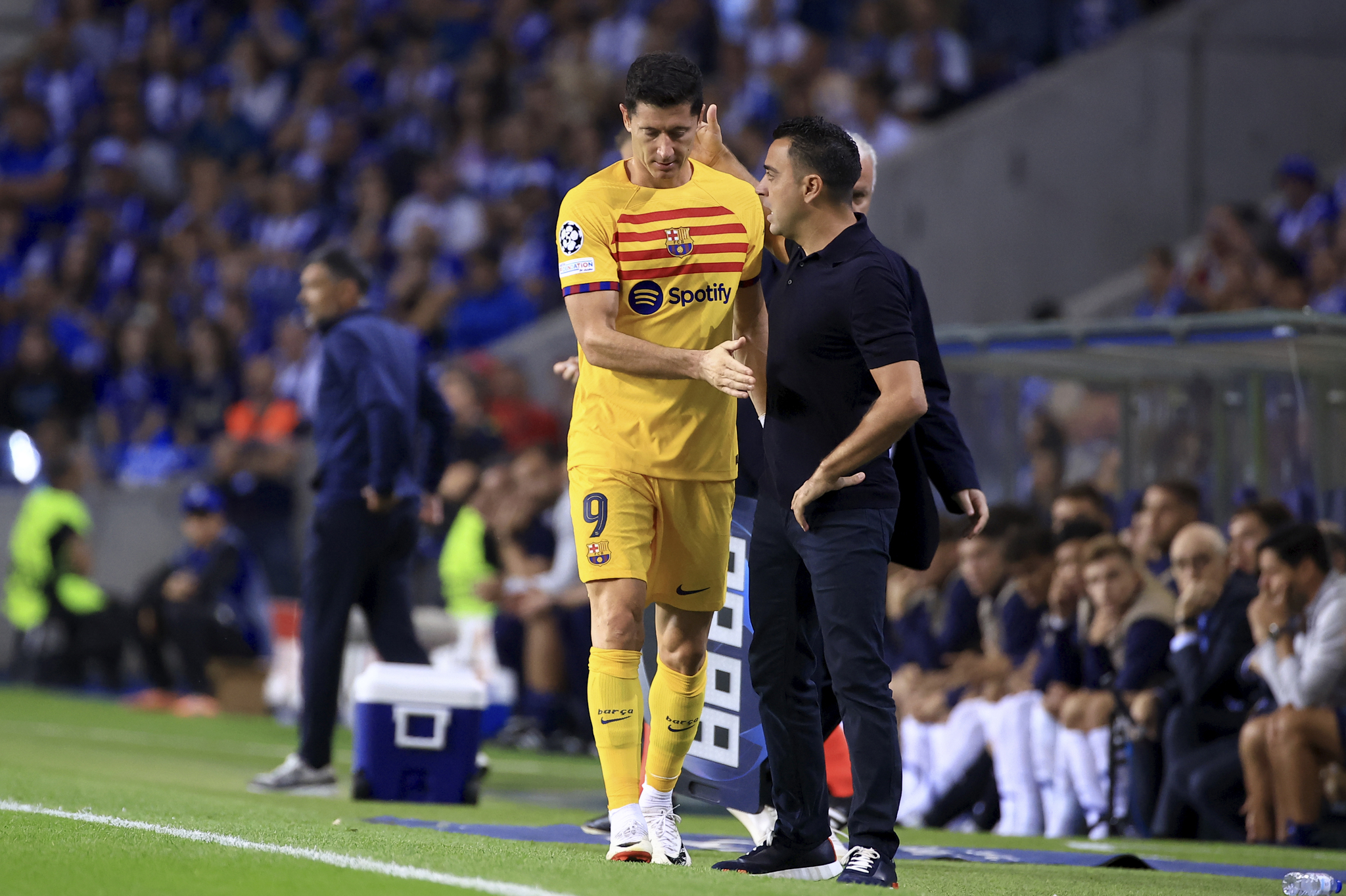 Lewandowski y Xavi cuando el polaco se retira del terreno de juego en Oporto.