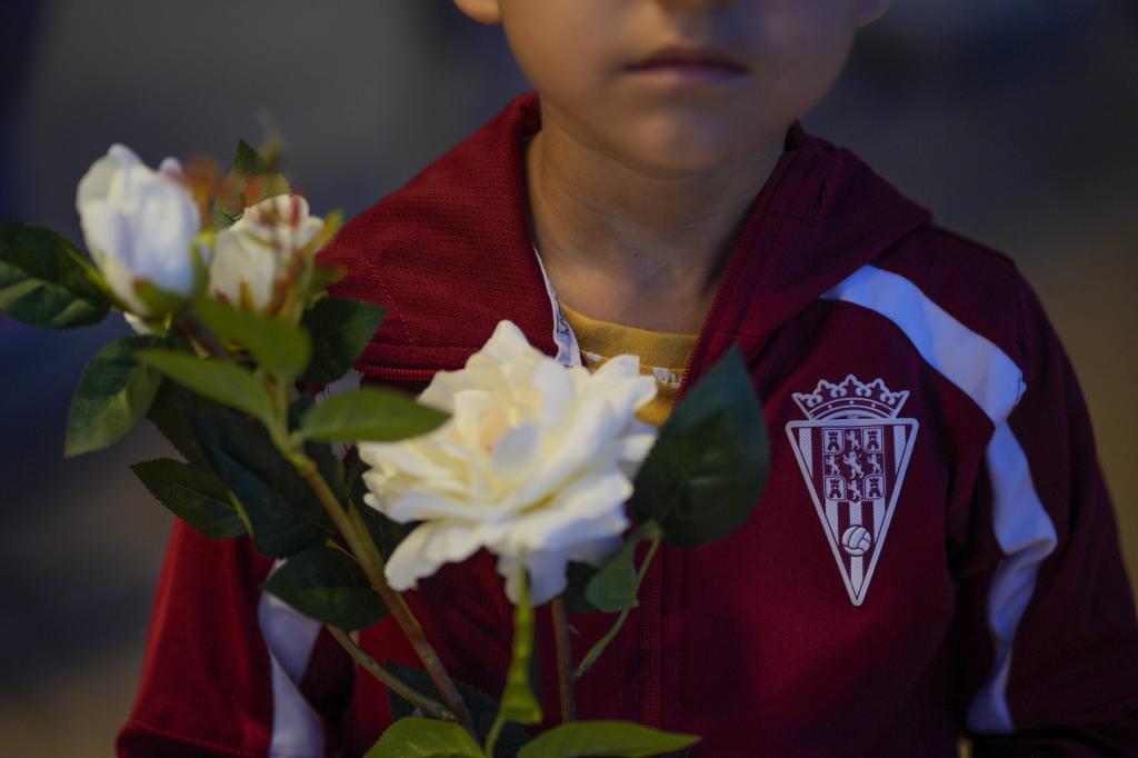 Un jugador de las inferiores del Crdoba, con el chandal y flores blancas, en el homenaje a Prieto.