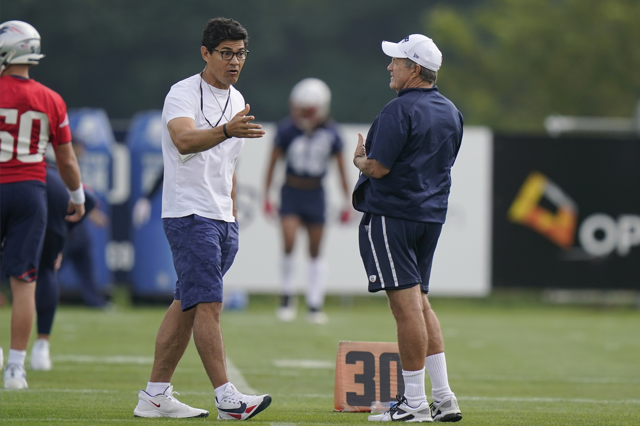 Former New England Patriots football player Tedy Bruschi, left, speaks with Patriots head coach Bill Belichick