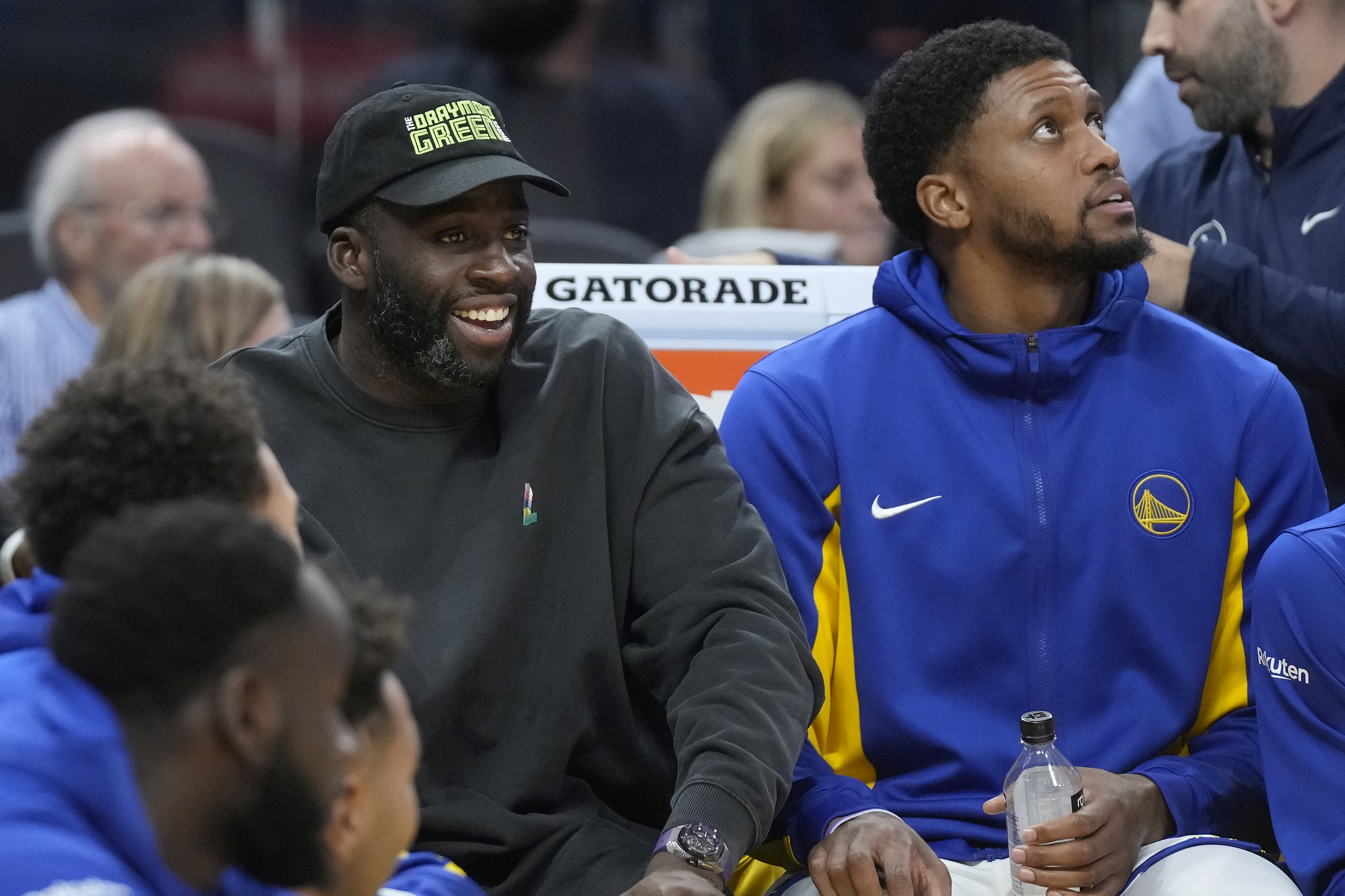 Injured Golden State Warriors forward Draymond Green, left, watches from the bench next to forward Rudy Gay during the first half of an NBA preseason basketball game against the San Antonio Spurs in San Francisco, Friday, Oct. 20, 2023. (AP Photo/Jeff Chiu)