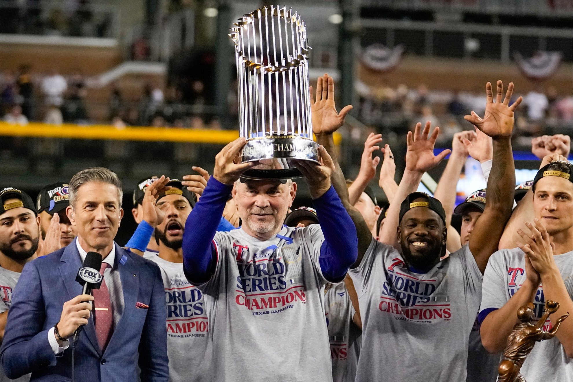 The Rangers Bruce Bochy lifts the Commissoners Trophy. This is the fourth time he has won the World Series as a manager.