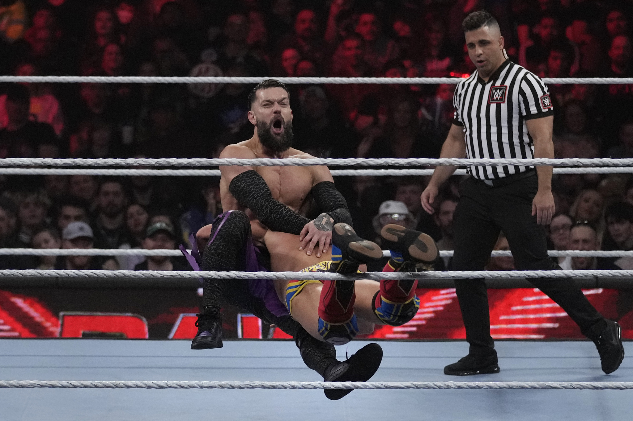 Wrester Finn Bálor, facing forward, is tackled by Johnny Gargano during WWE Monday Night RAW