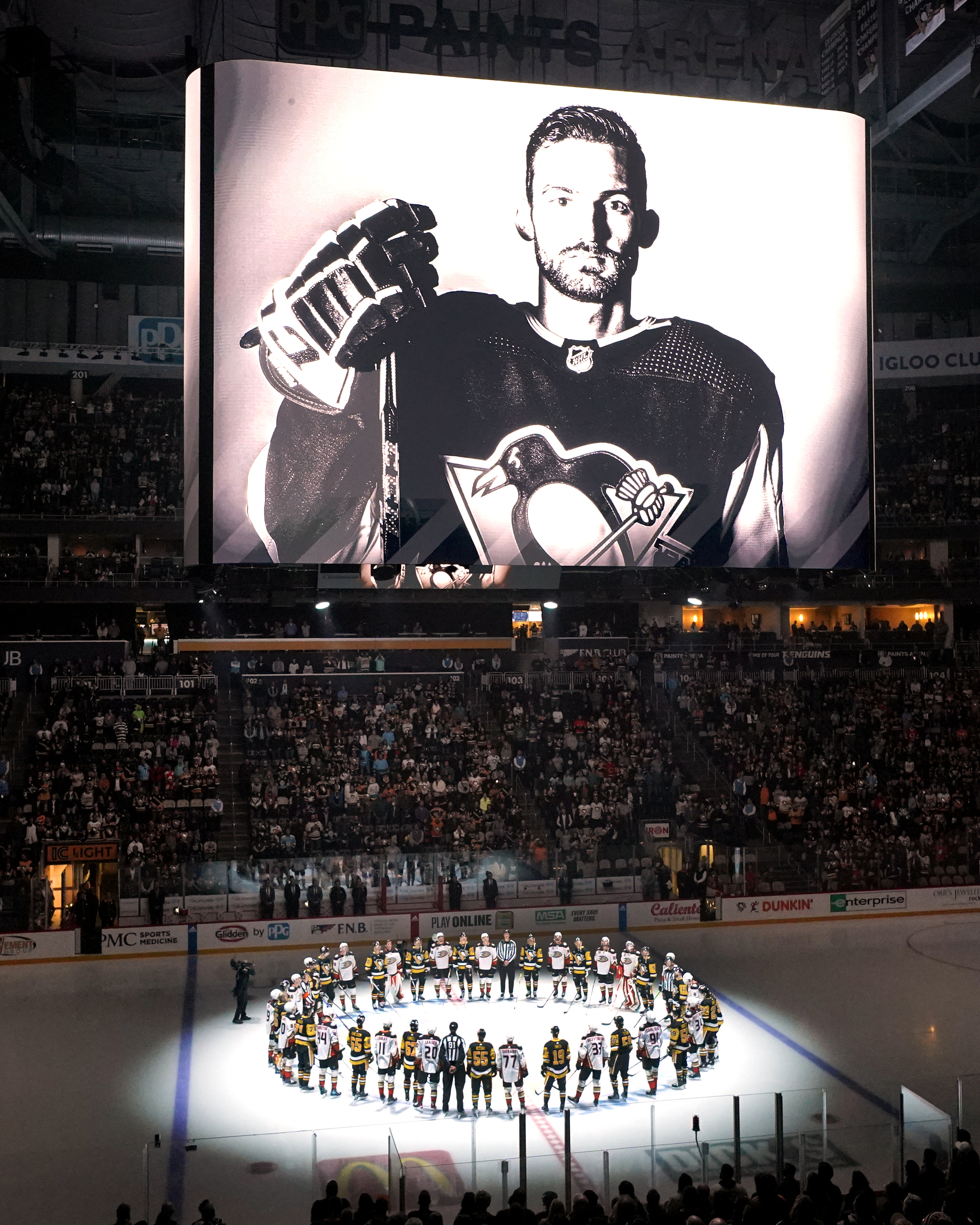 The Pittsburgh Penguins and Anaheim Ducks gather at center ice to honor Adam Johnson