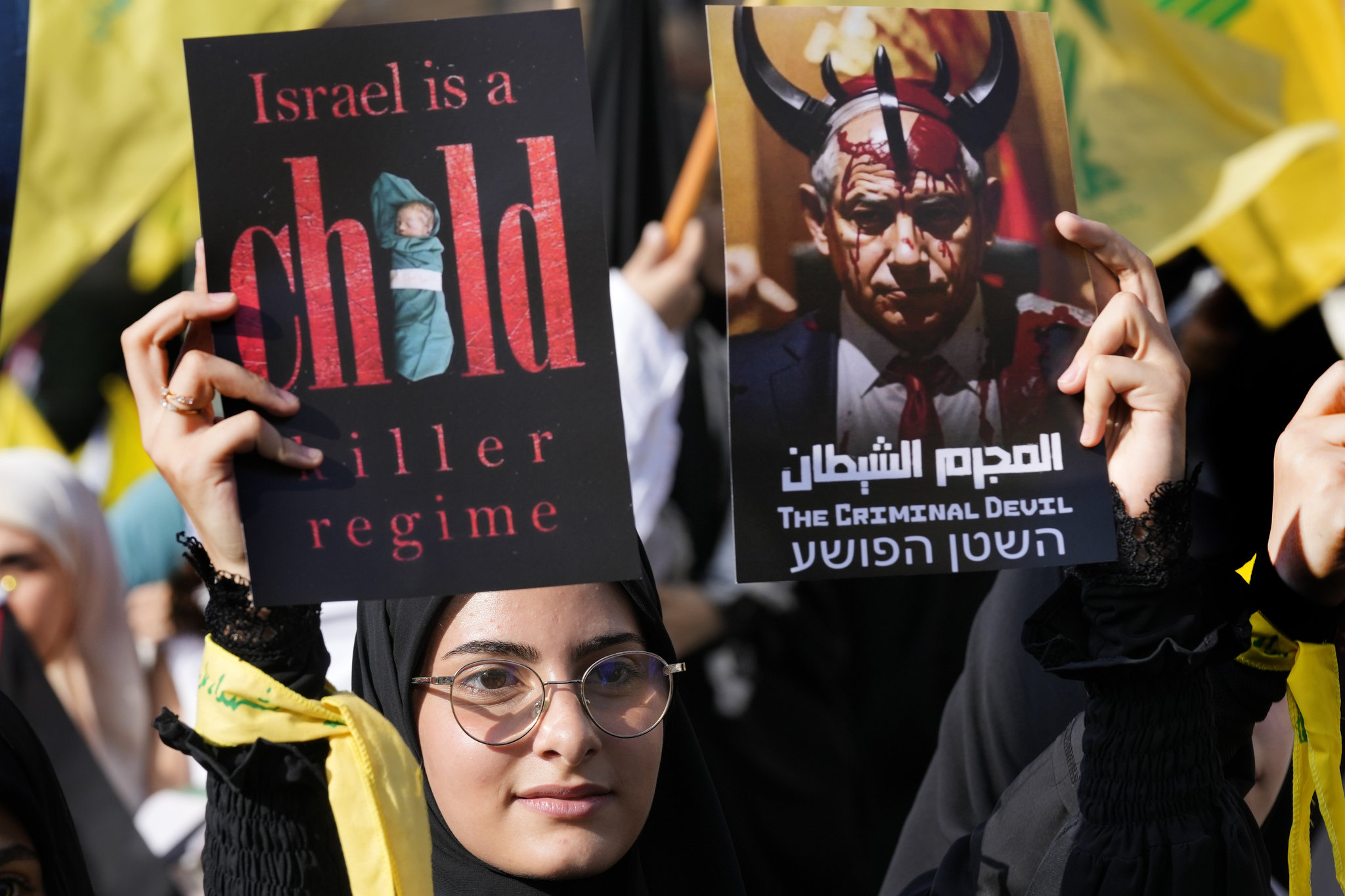 A supporter of the Iranian-backed Hezbollah group hold posters against the Israeli Prime Minister Benjamin Netanyahu