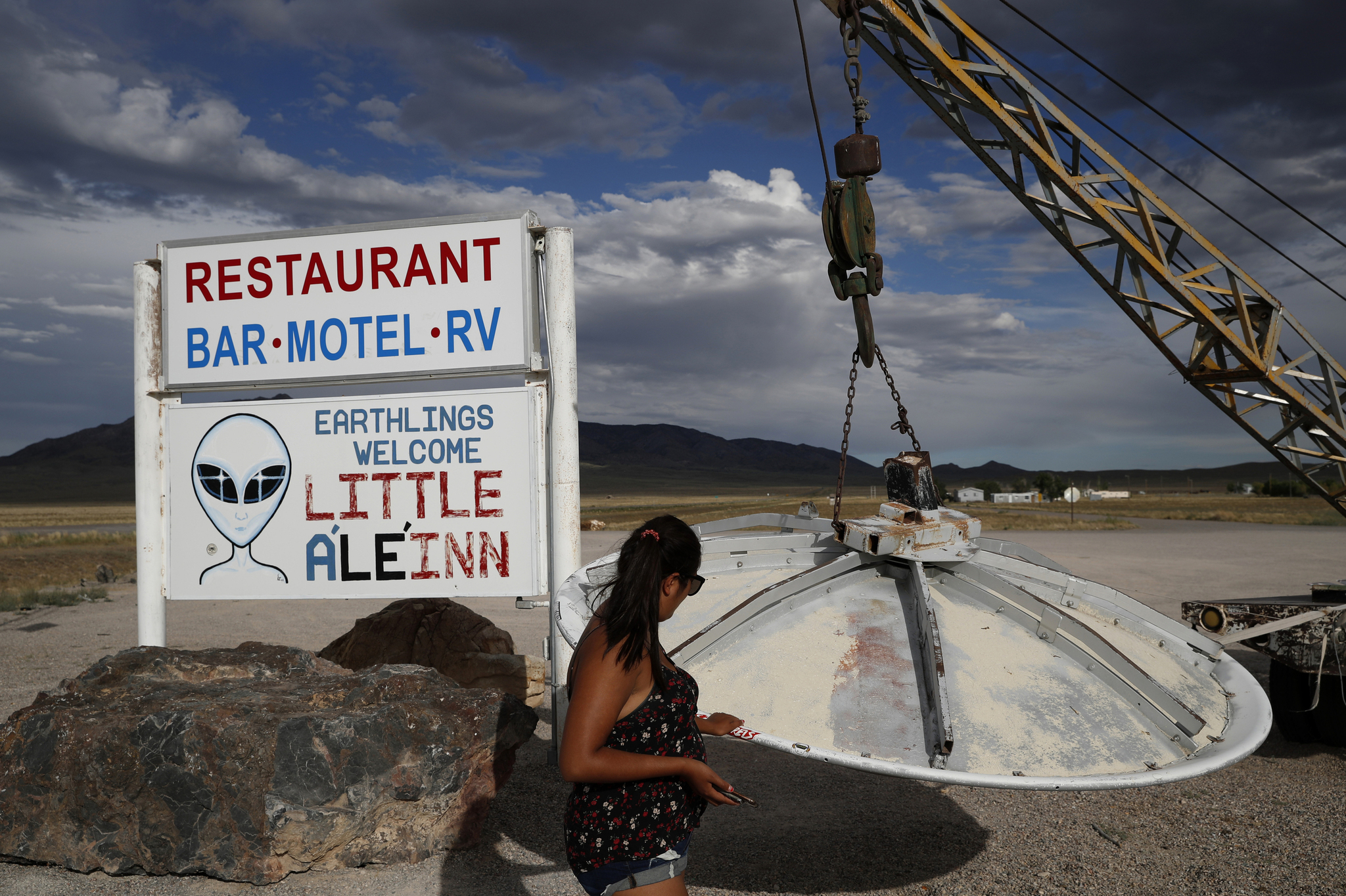 A woman looks at a UFO display outside of the Little ALeInn, in Rachel, Nev., the closest town to Area 51