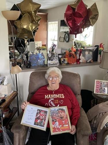 Charlotte Holt proudly poses with the Mahomes-themed care package she received from the Chiefs.
