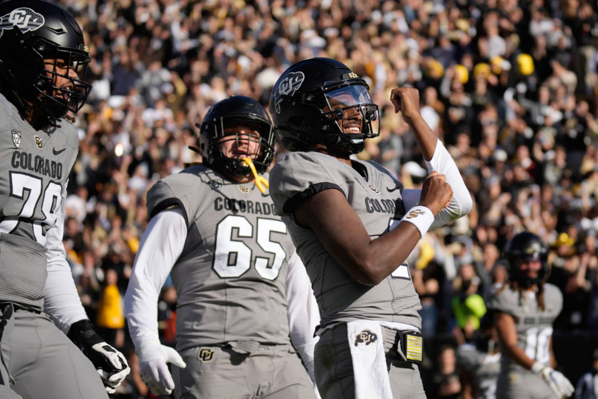 Colorado quarterback Shedeur Sanders, right, gestures to the crowd after scoring a touchdown