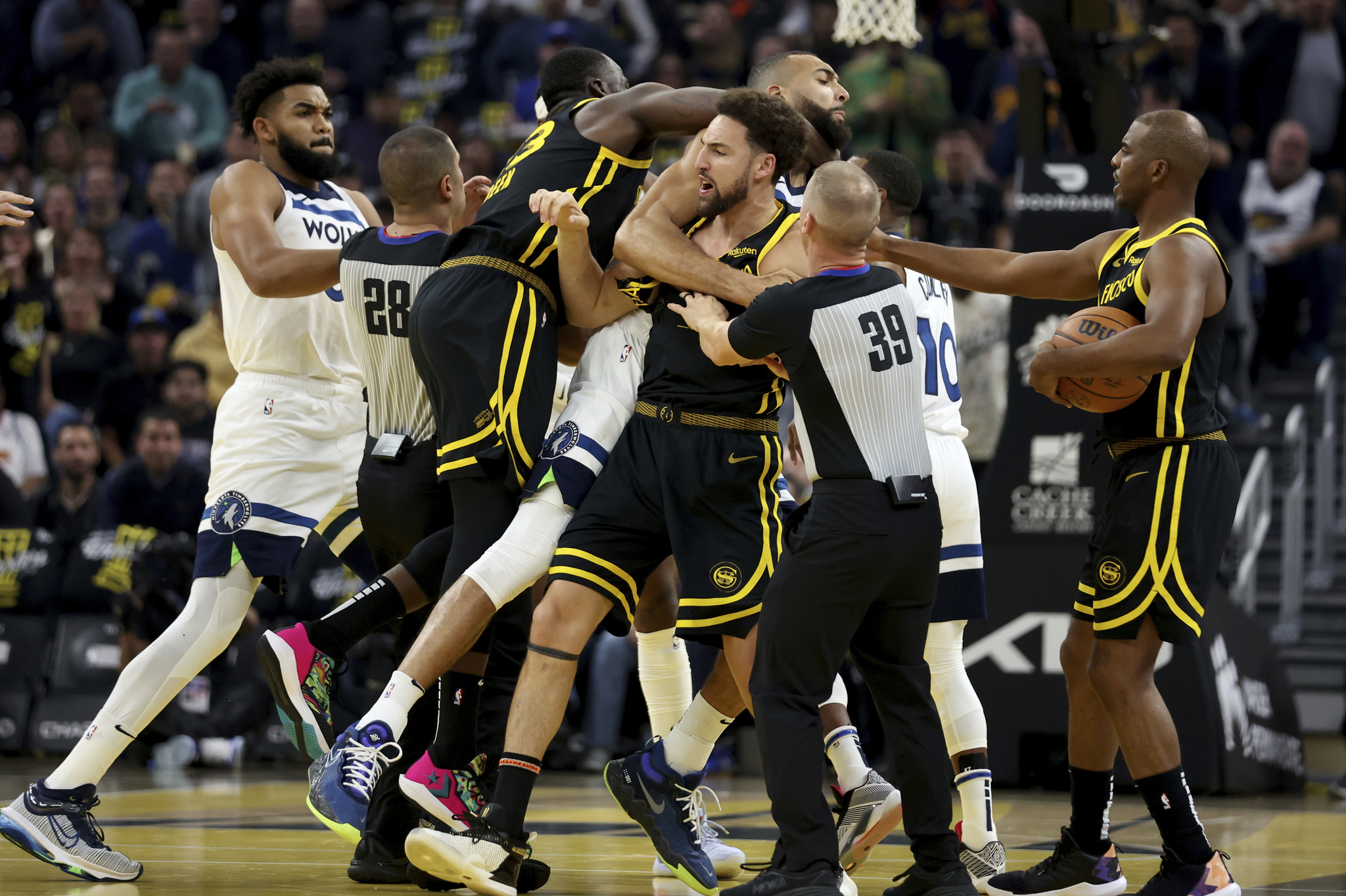 Golden State Warriors guard Klay Thompson, front, Draymond Green, left, gets into an altercation with Minnesota Timberwolves center Rudy Gobert, back.