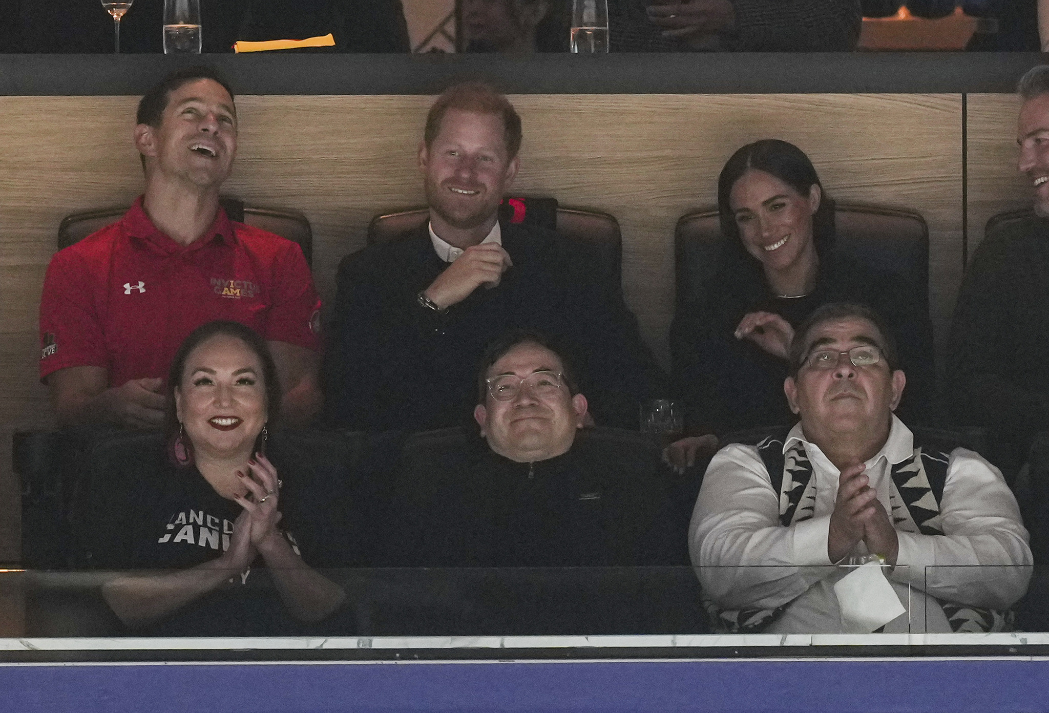 Prince Harry, top second from left, and Meghan Markle, top right, watch the Vancouver Canucks and San Jose Sharks