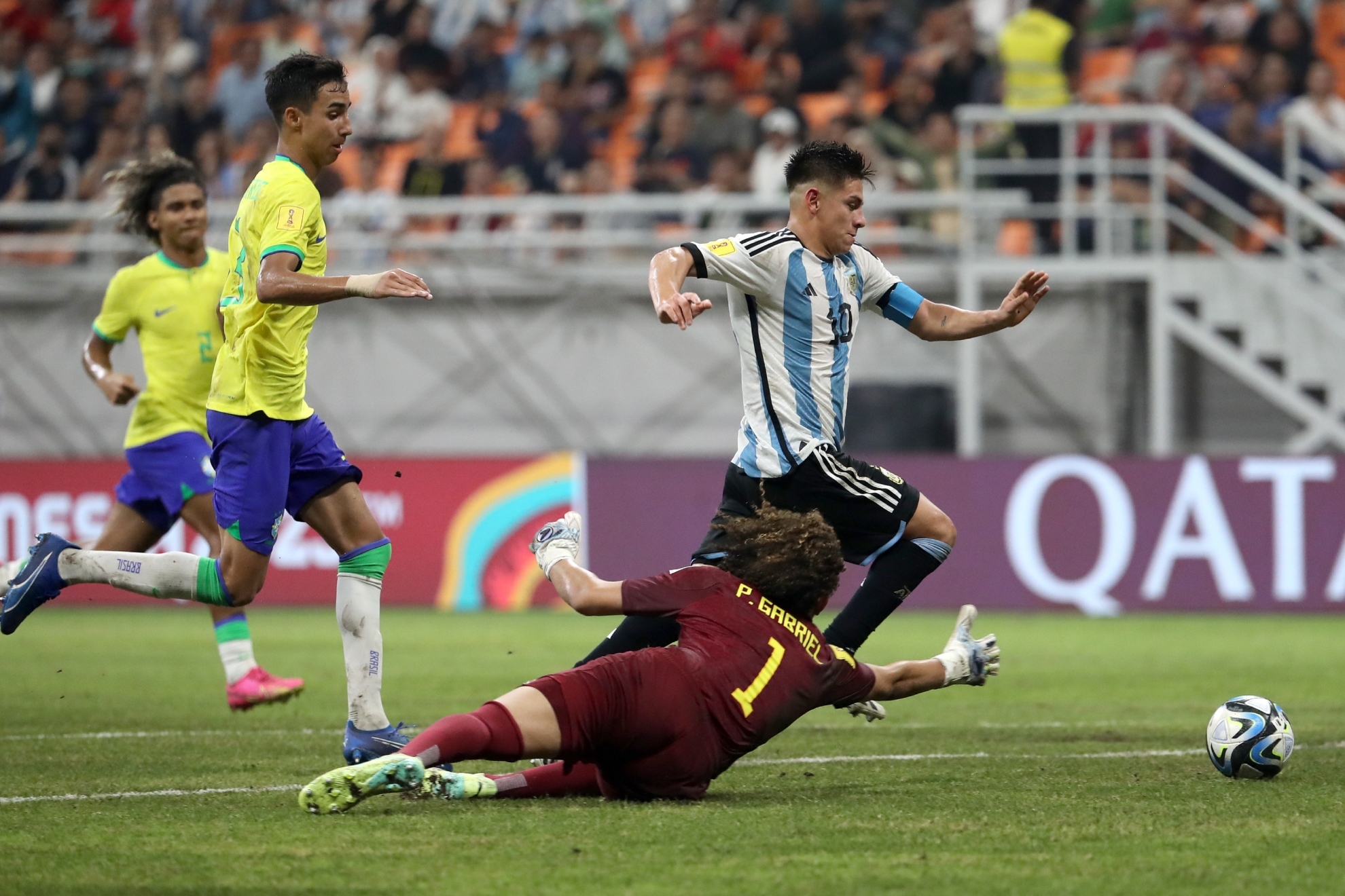 Claudio Echeverri regatea al meta de Brasil para anotar el tercero de Argentina.