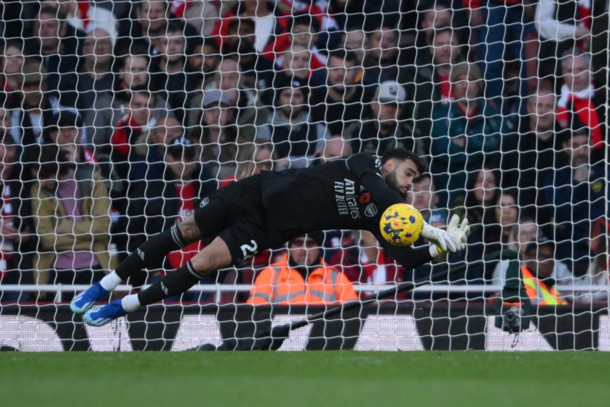 David Raya ataja un balón con el Arsenal.