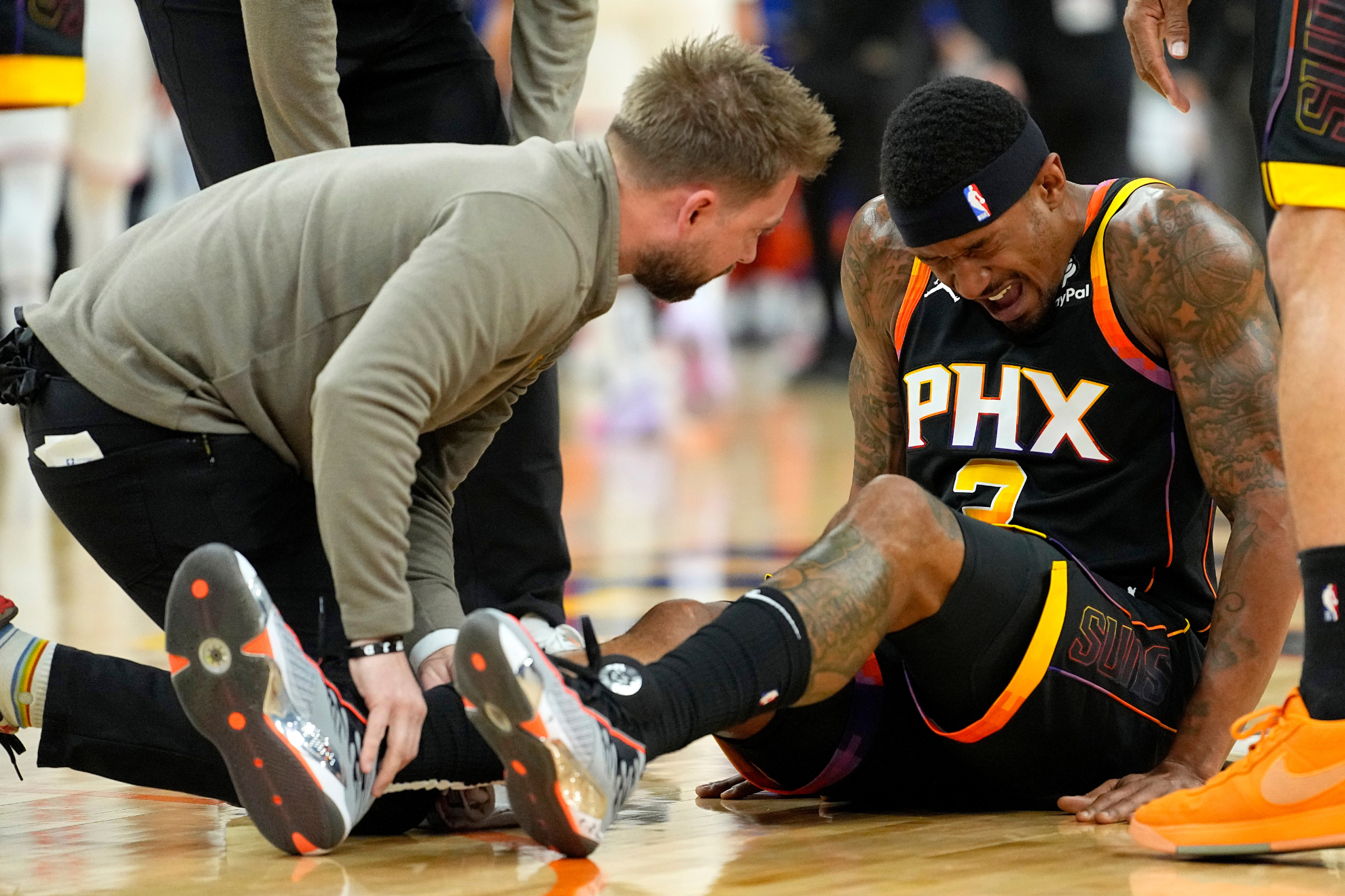 Beal (right) grimaces in pain after rolling his ankle on Friday night.