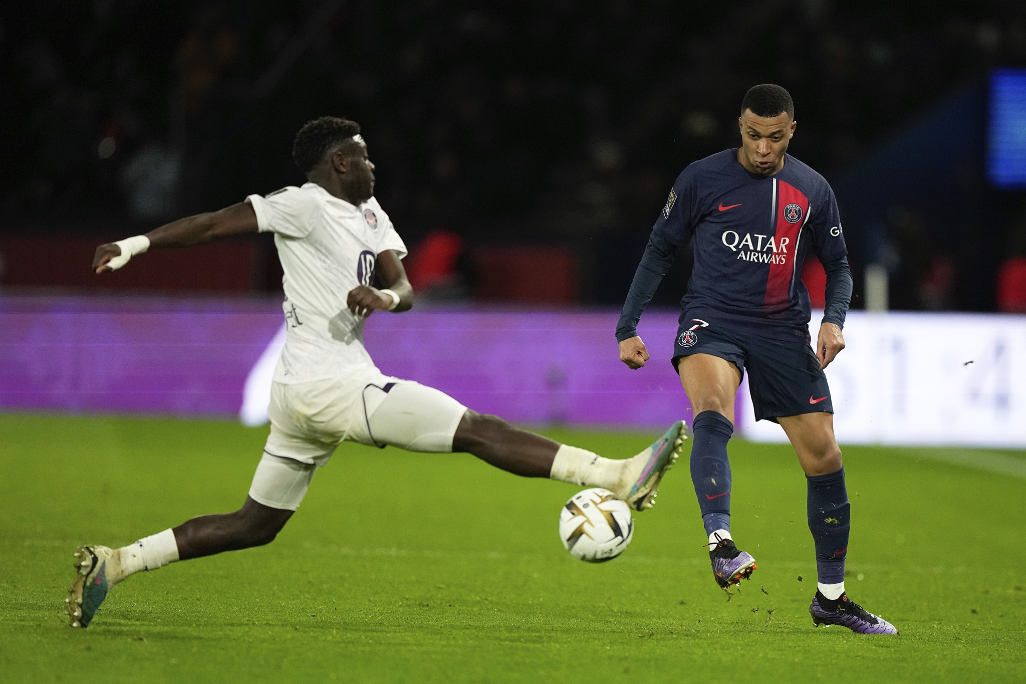 Toulouse's Christian Mawissa, left, tackles Kylian Mbappe