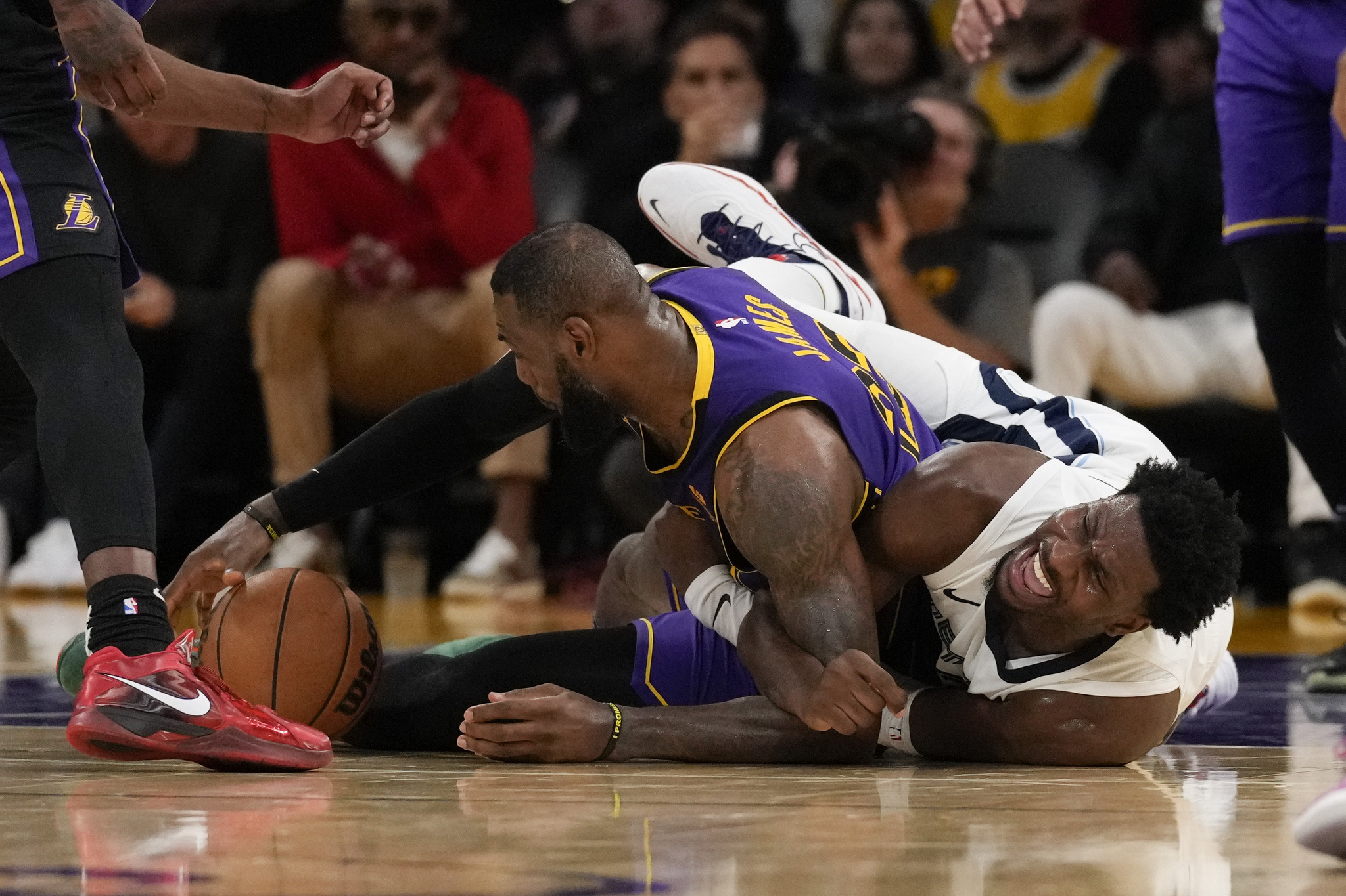 Los Angeles Lakers forward LeBron James (23) and Memphis Grizzlies forward Jaren Jackson Jr. (13) reach for a loose ball during the second half of an NBA basketball game in Los Angeles, Friday, Jan. 5, 2024. (AP Photo/Ashley Landis)