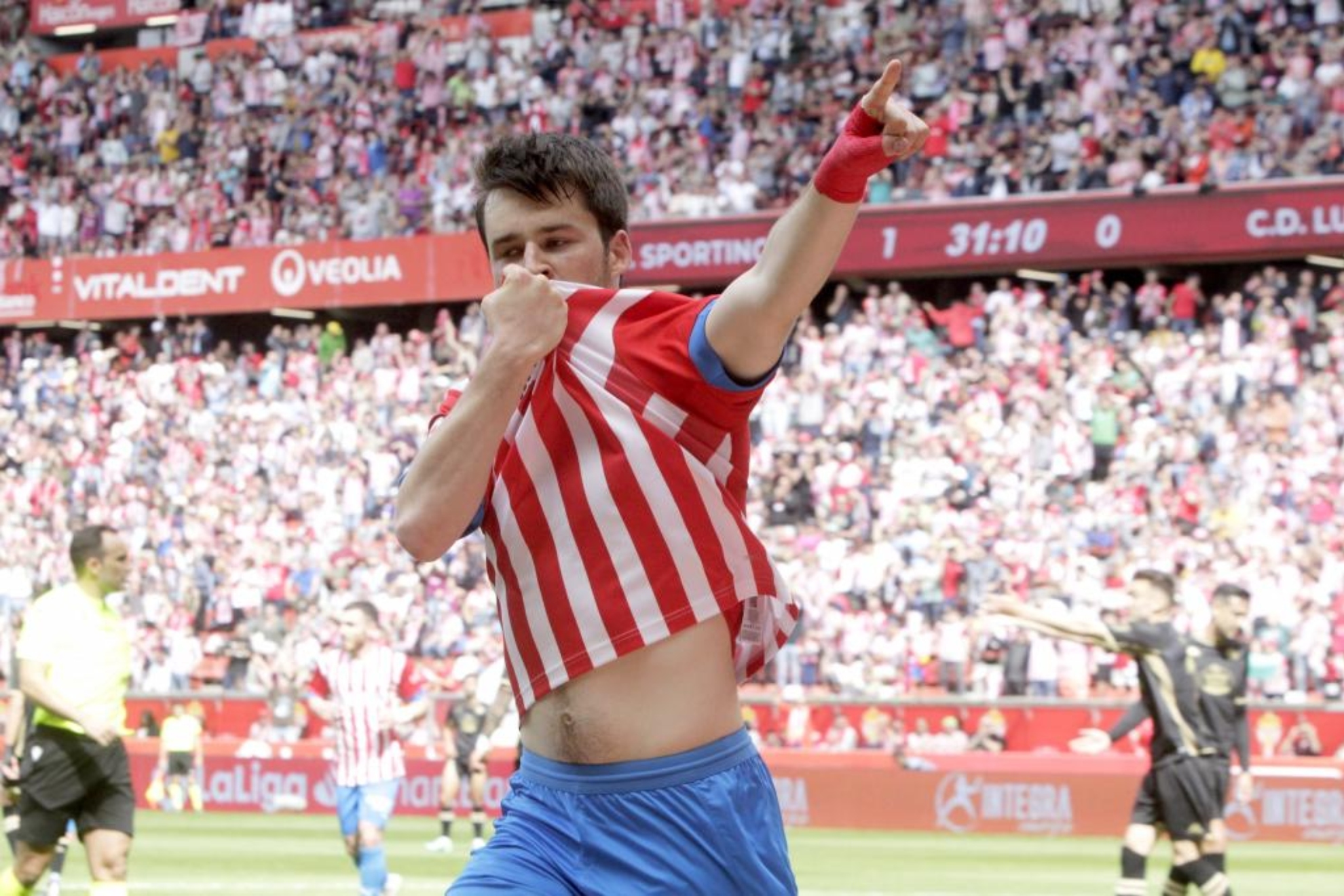 Guille Rosas celebra uno de sus goles besando el escudo del Sporting