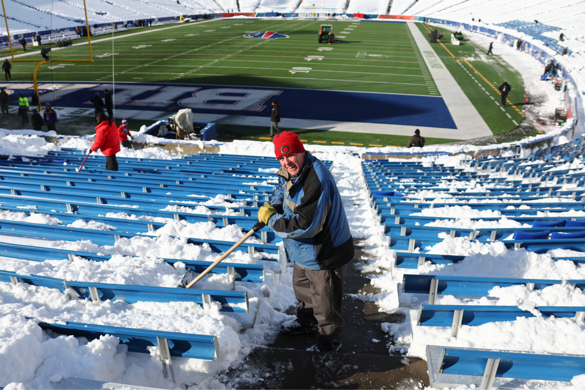 A stadium worker helps to clear some snow-covered seats in Buffalo.