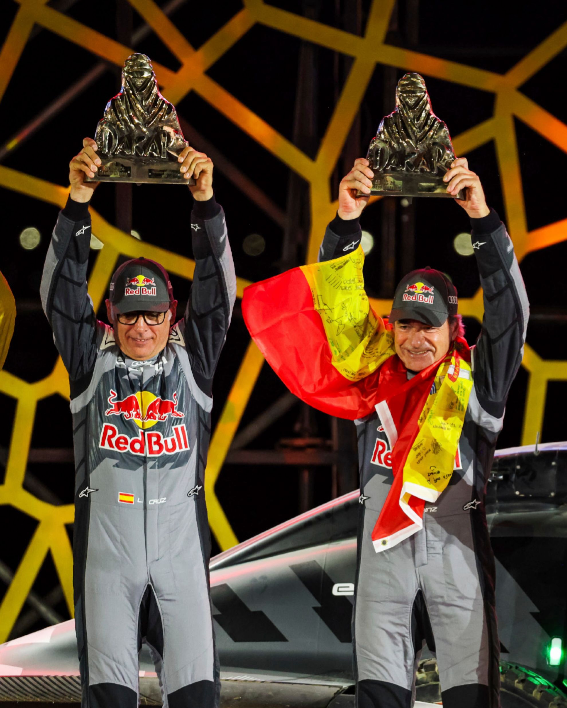 Carlos Sainz y Lucas Cruz, levantando su cuarto trofeo del Touareg.