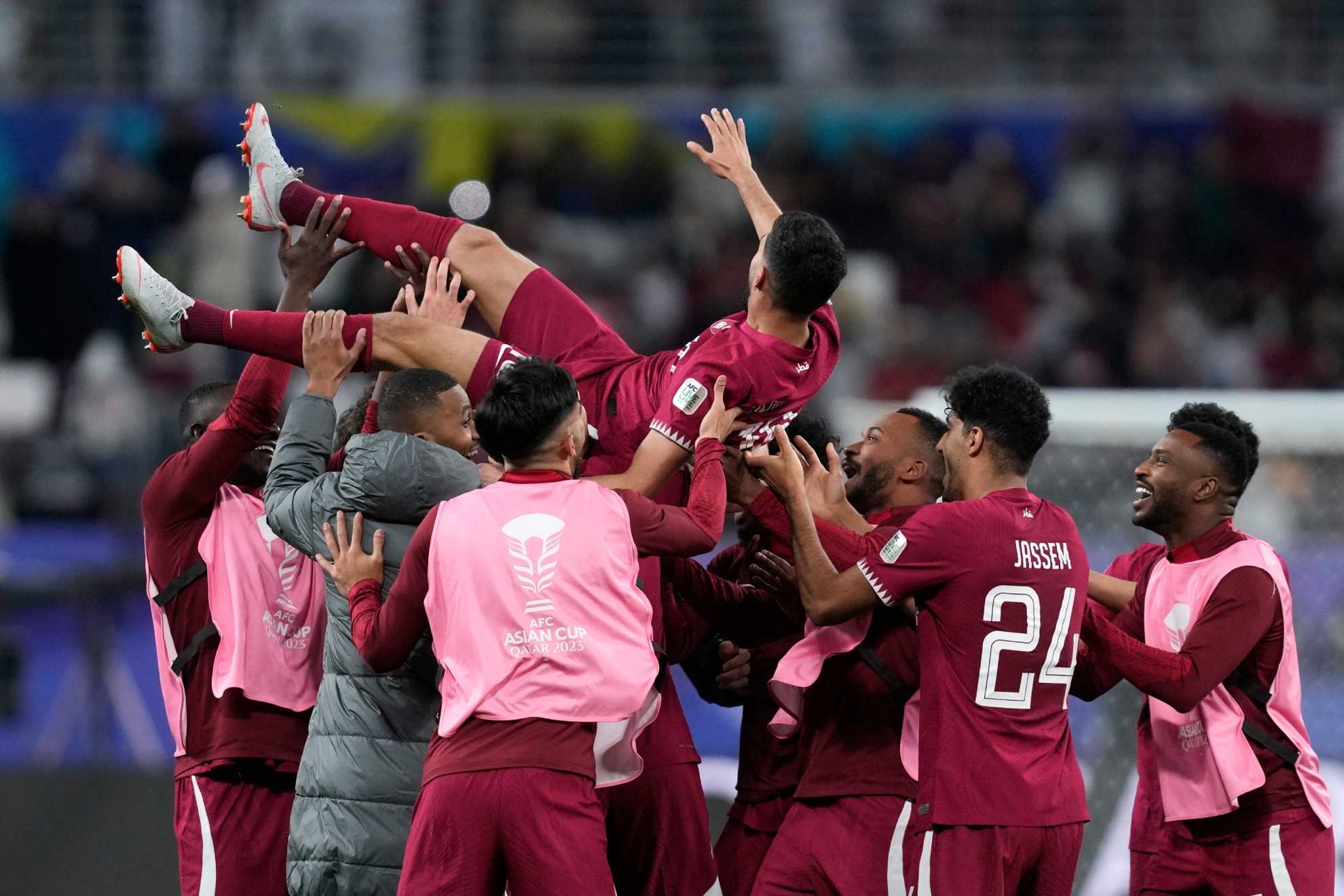 Los jugadores de Qatar mantean a Hassan Al Haydos.