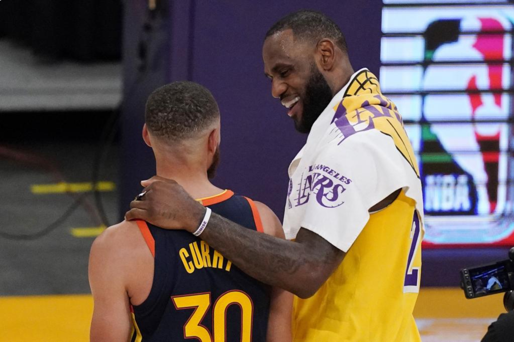 LeBron James y Stephen Curry charlan después de un partido.